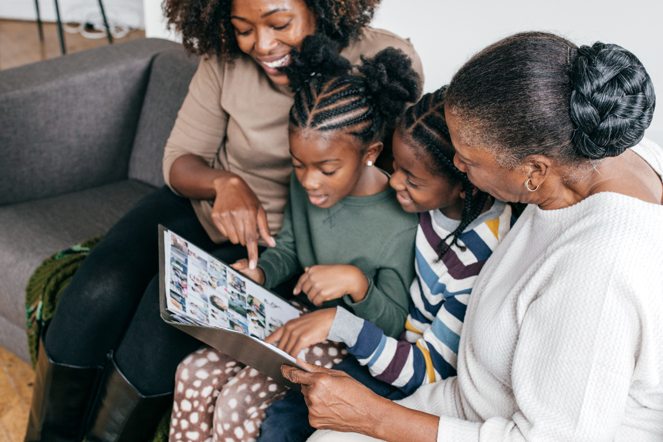 Grandmother, daughter and grandkids looking at photo album