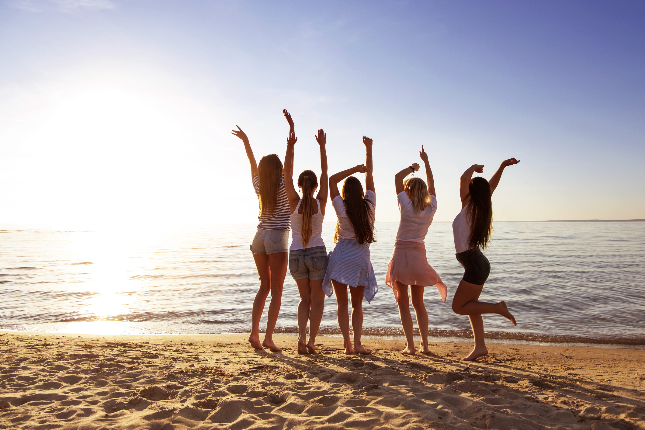 Happy girlfriends having fun sunset lake