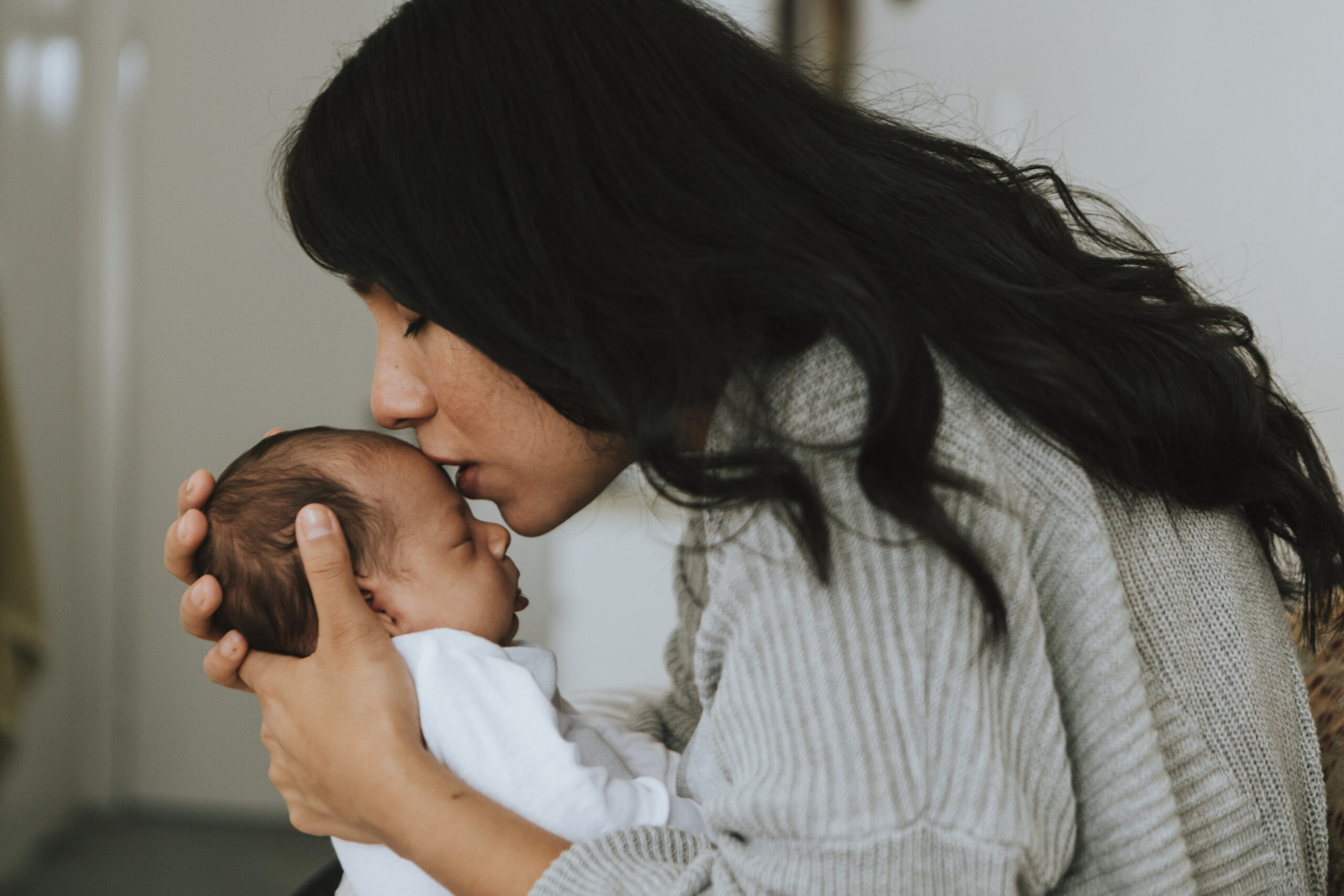 Loving mother kissing her infant baby