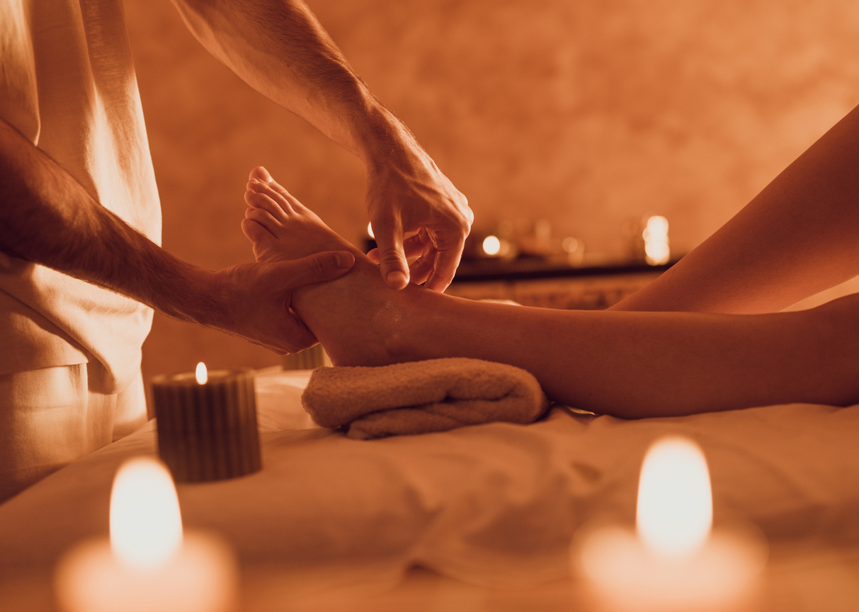 Unrecognizable therapist massaging customer's foot at health spa.