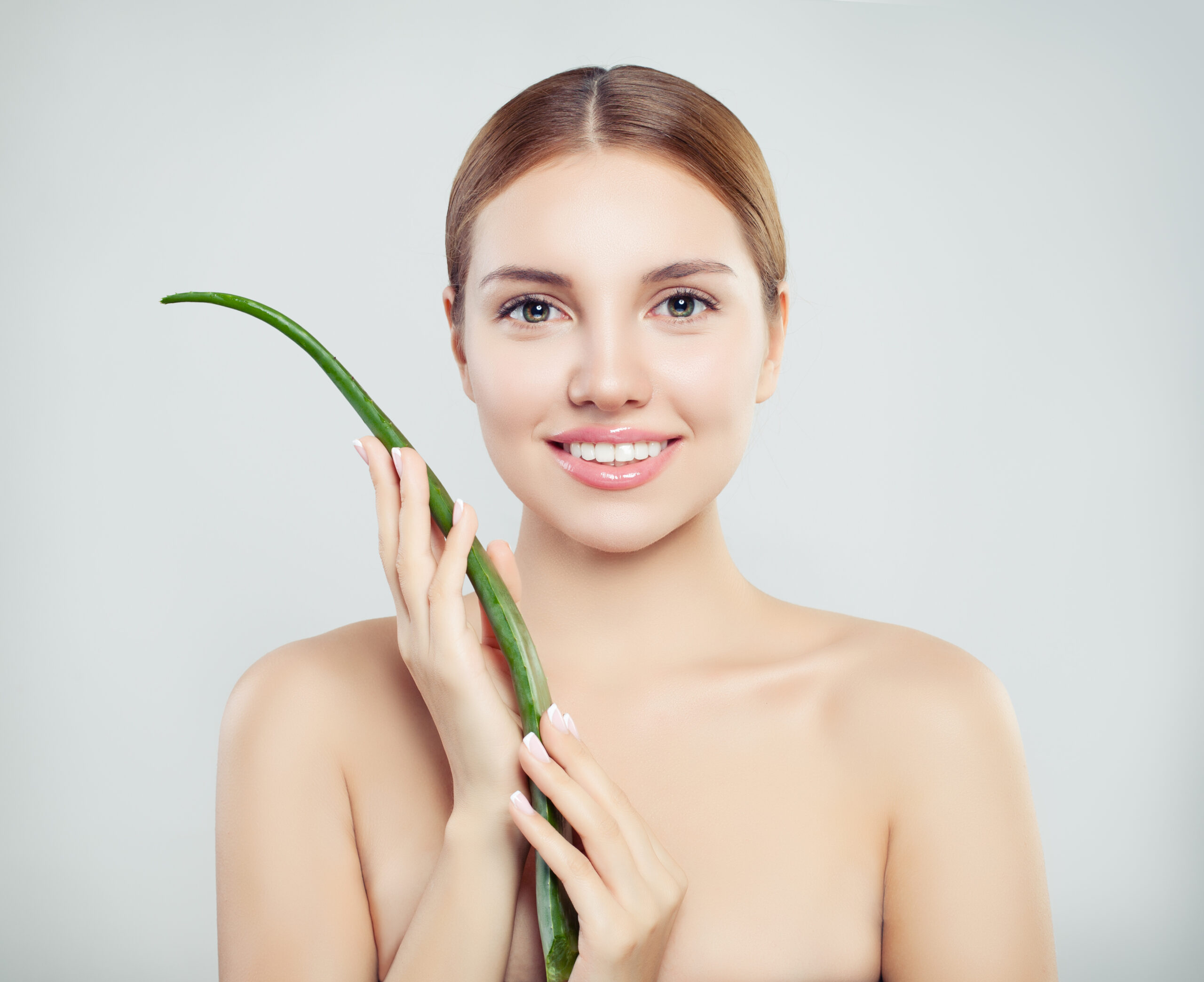 Young smiling woman with aloe vera leaf