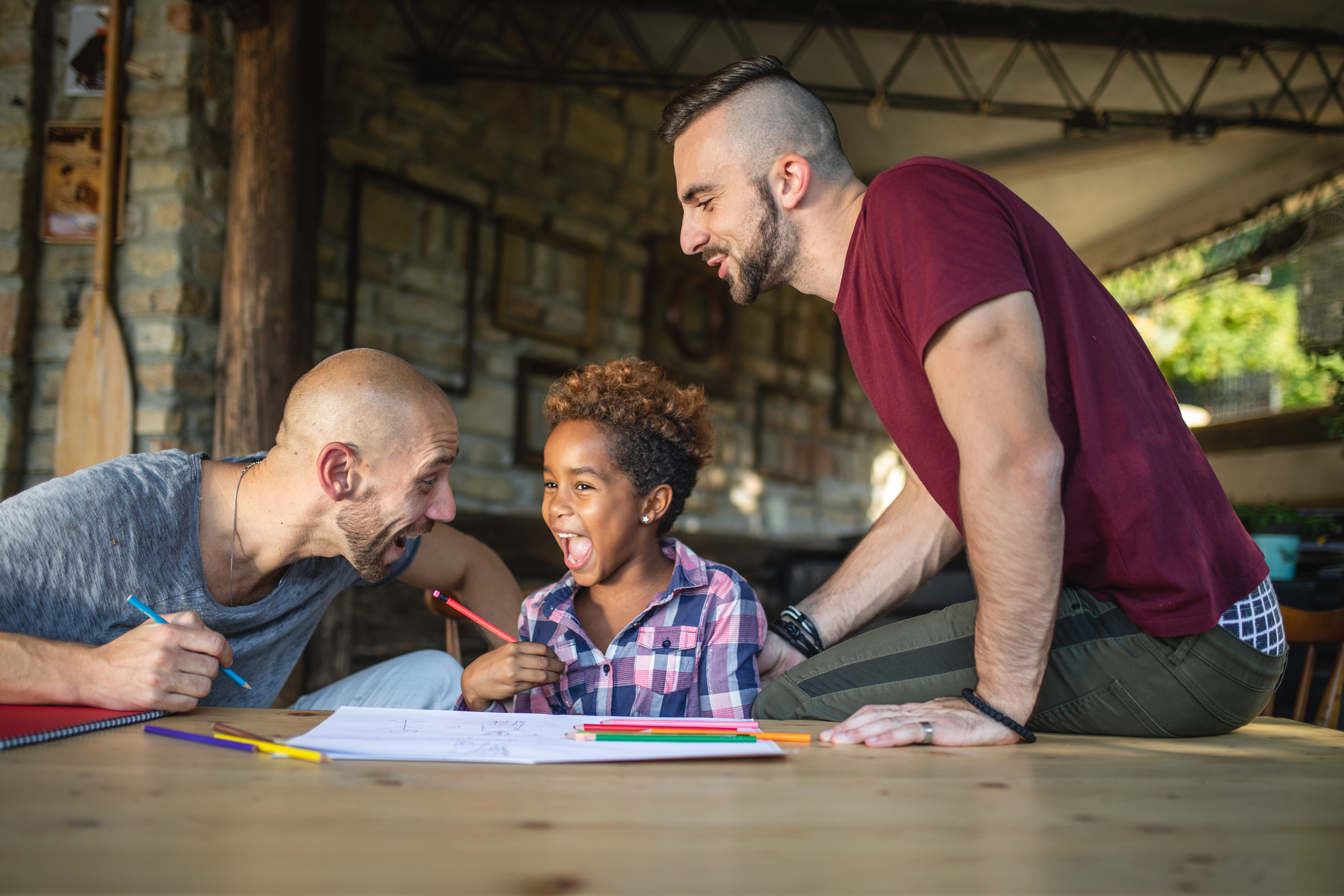 Cheerful family of three having fun while doing a homework together