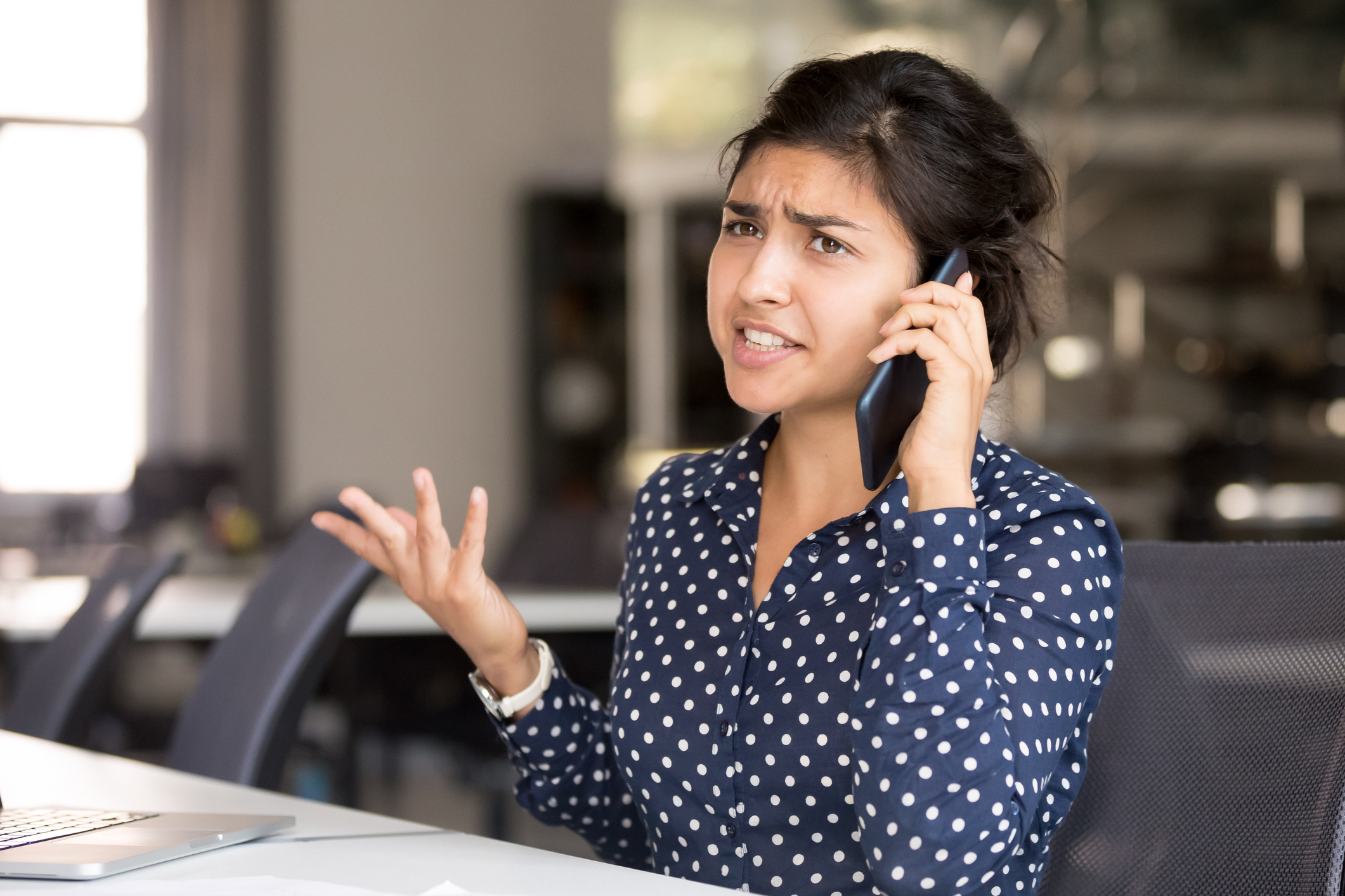 Outraged Indian female employee talking by phone