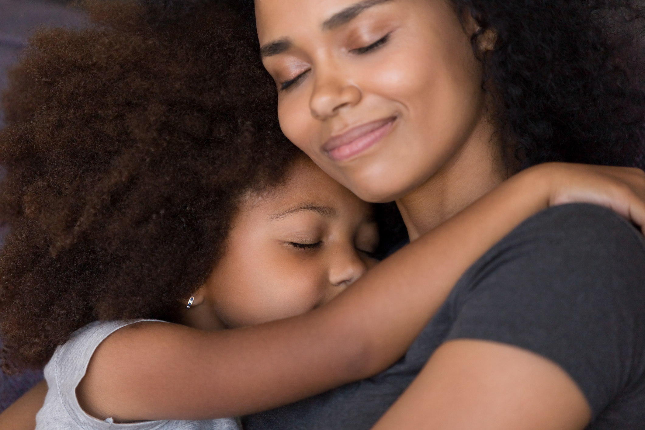 Loving single black mother hugs cute daughter feel tenderness connection