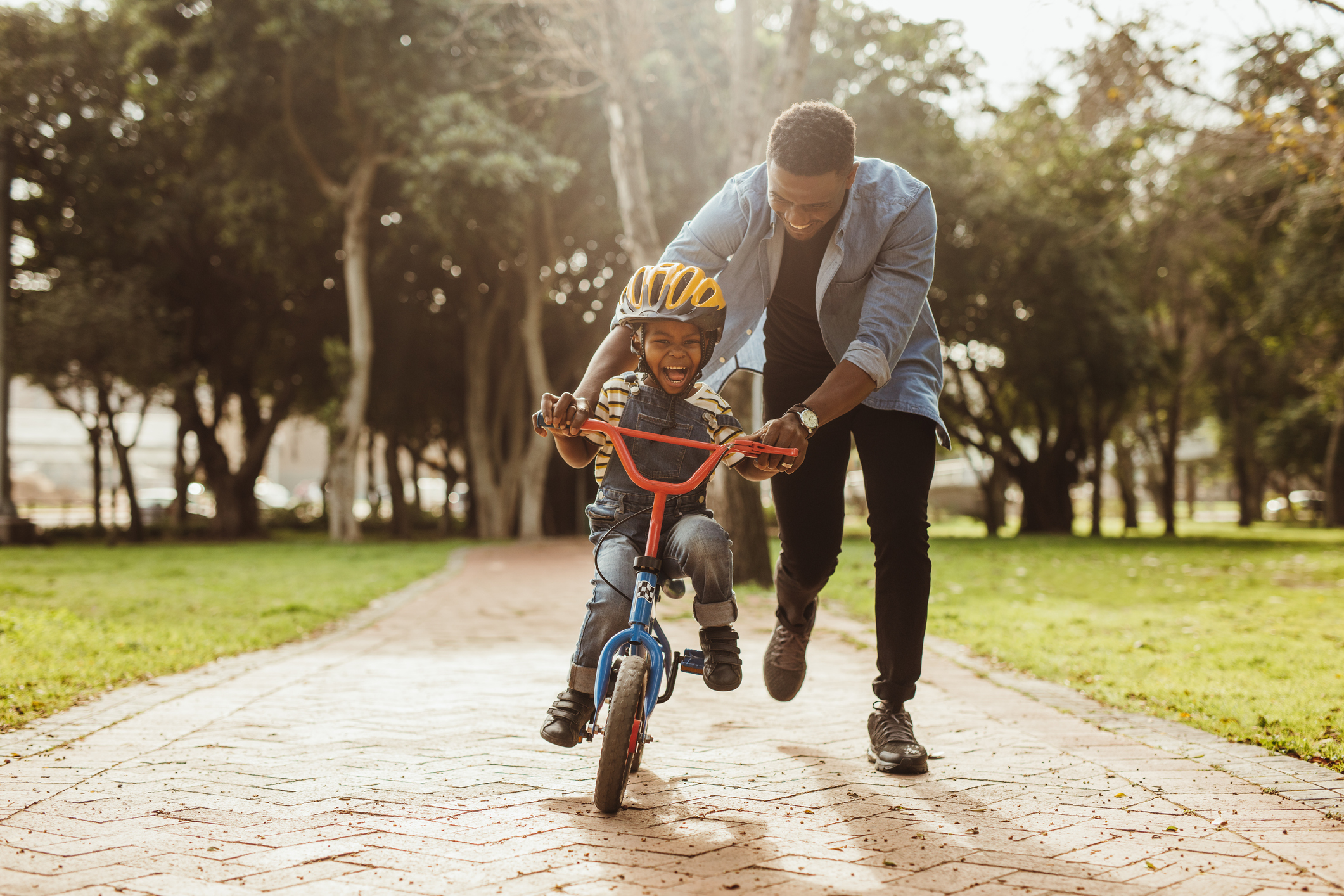 Father teaching his son cycling at park