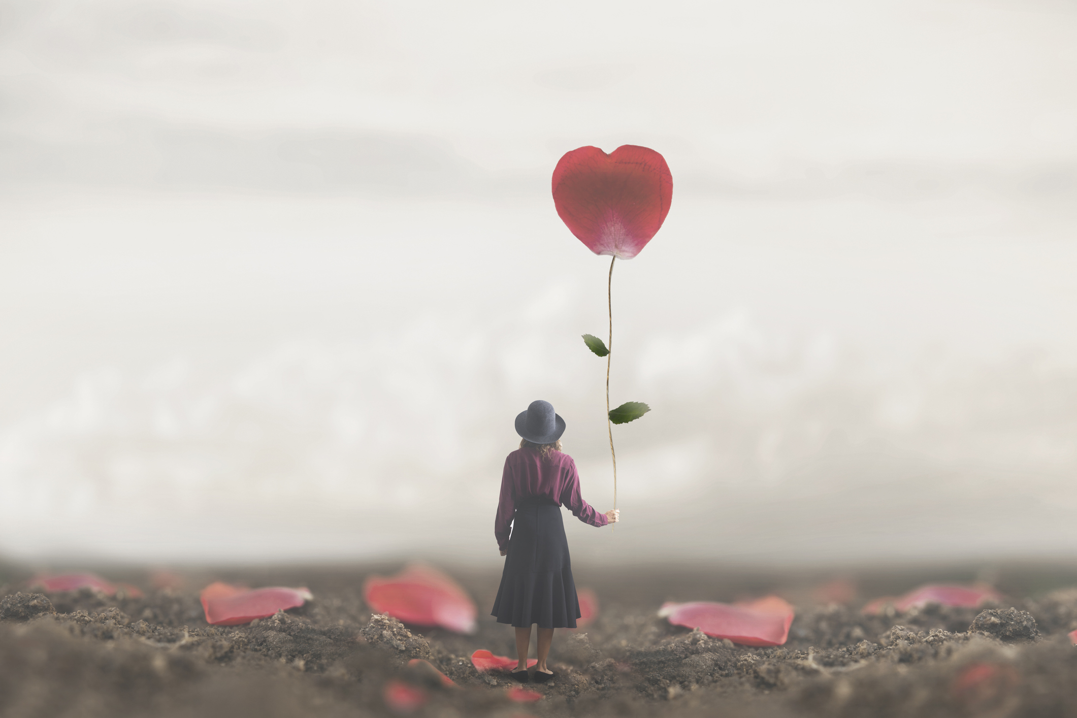 lonely romantic woman holds a giant petal made to heart