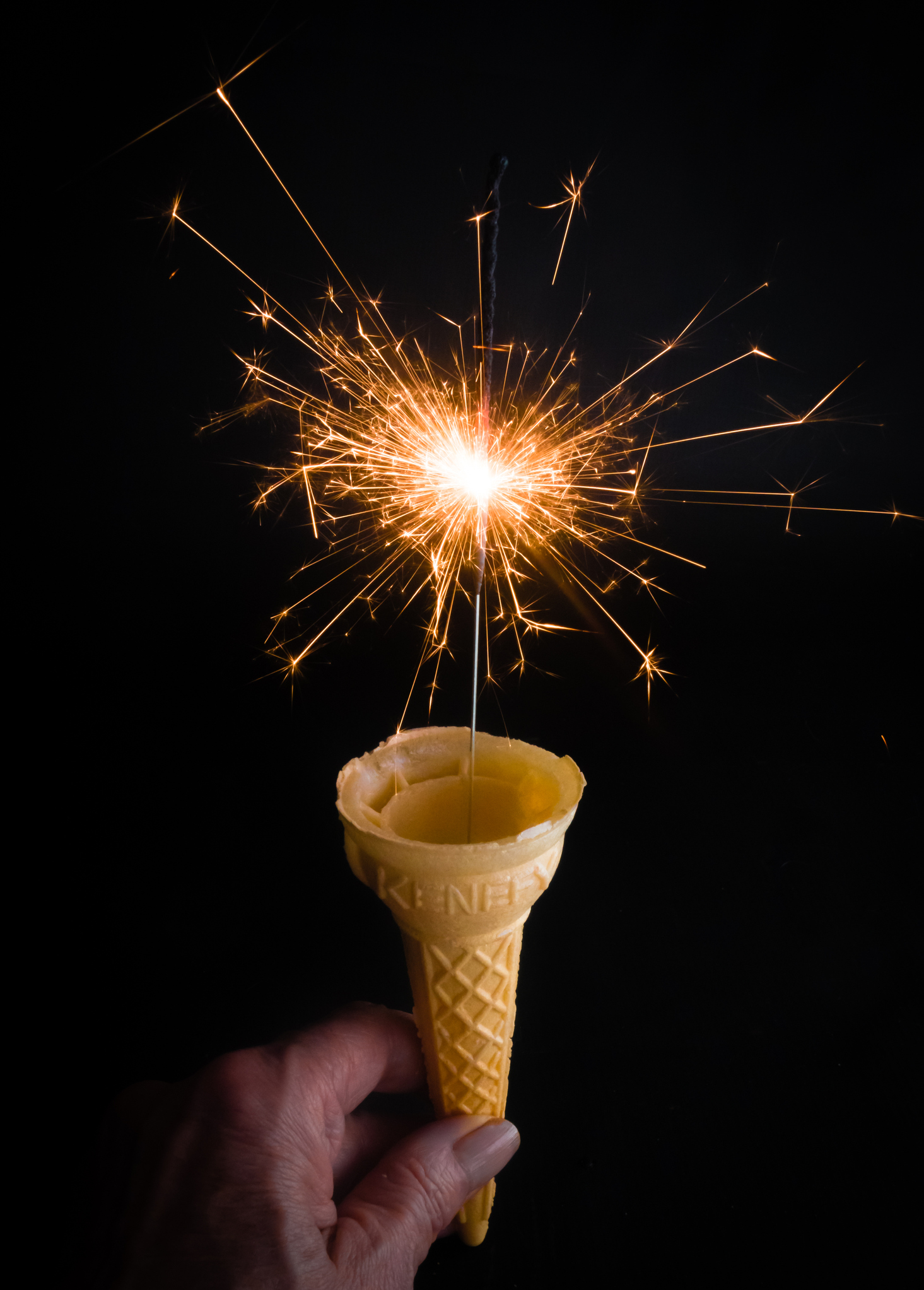 Empty Ice-cream Cone with Sparkler on Black Background