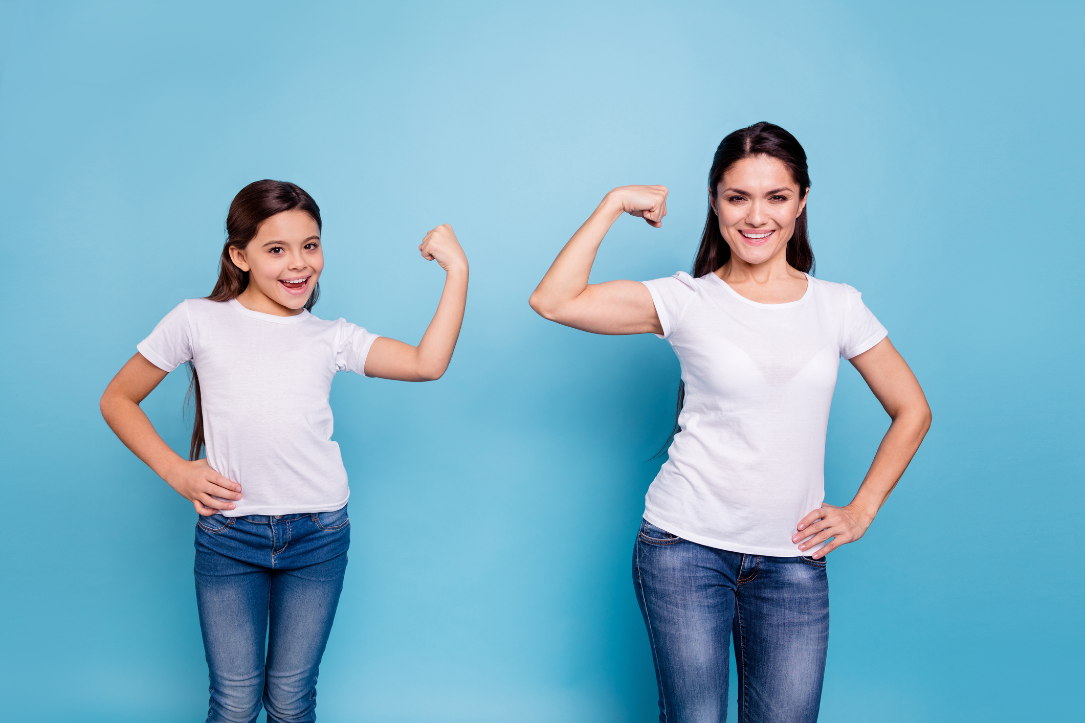 Close up photo two people brown haired mum mom small little daughter hand on biceps who run world girls wear white t-shirts isolated bright blue background