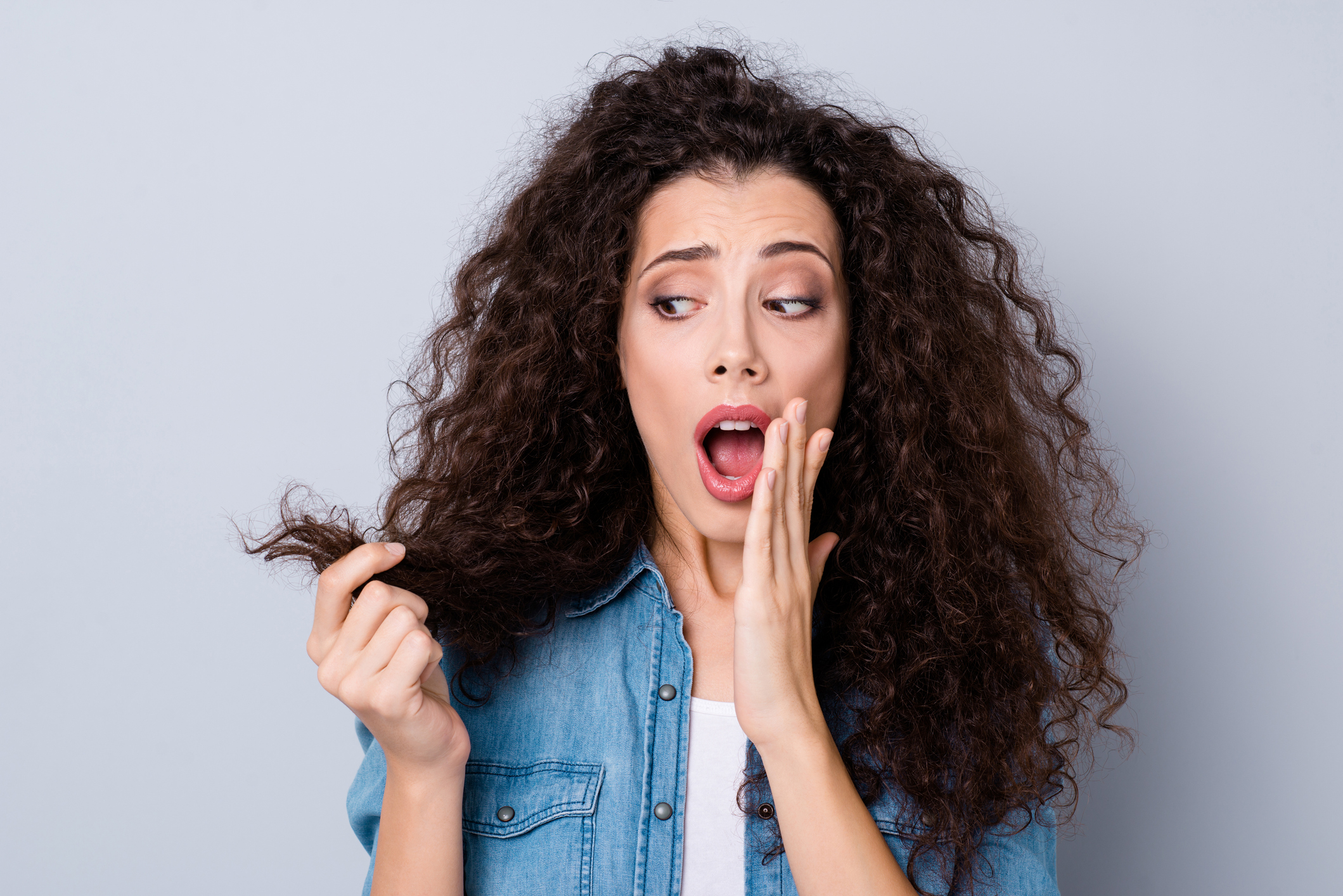 Close-up portrait of her she nice cute charming attractive worried shocked wavy-haired girl holding looking at dry wealth curls thinking about solution repair isolated over gray pastel background