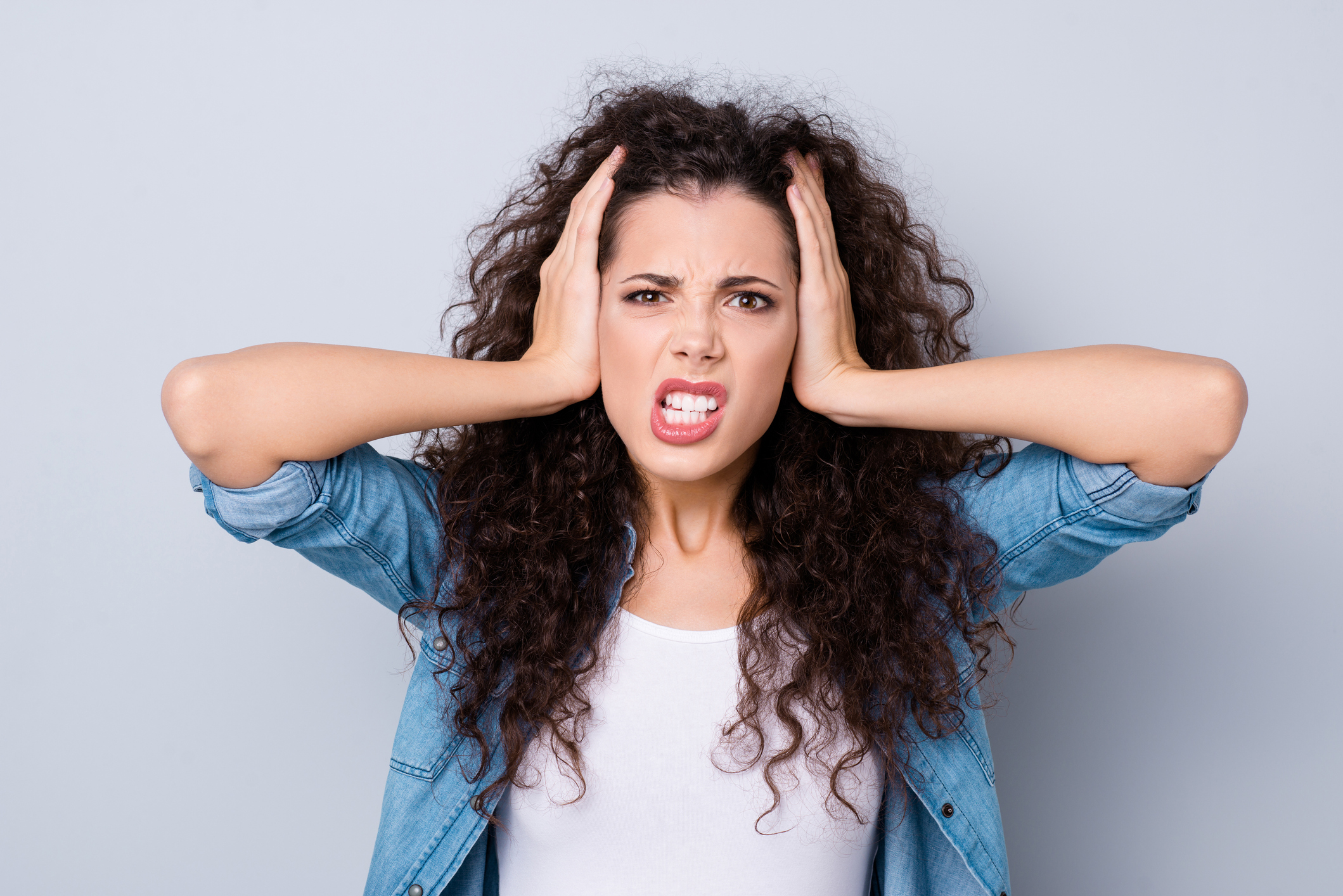 Close up photo stress amazing beautiful attractive her she lady hands arms shut hide ears terrible pain sick unwell despair wearing casual jeans denim shirt clothes outfit isolated grey background