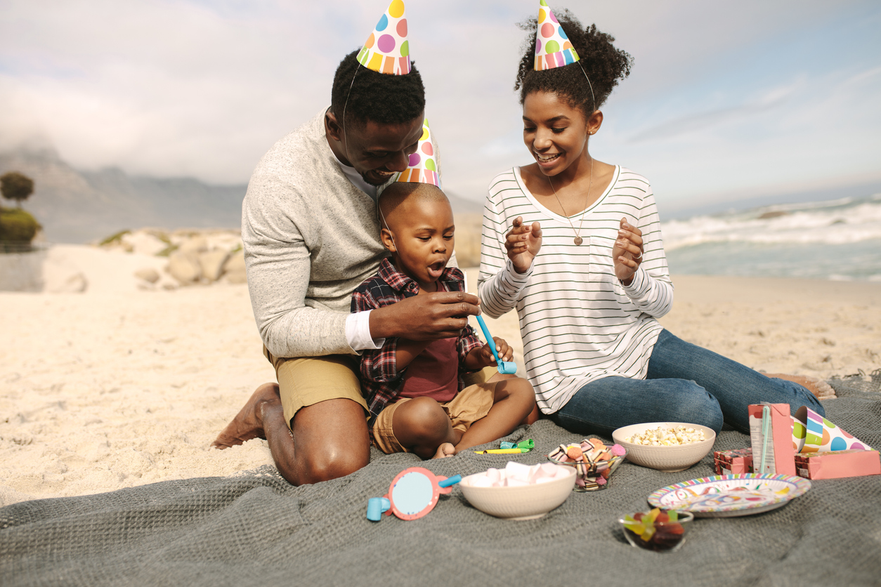 Family celebrating son's birthday on beach