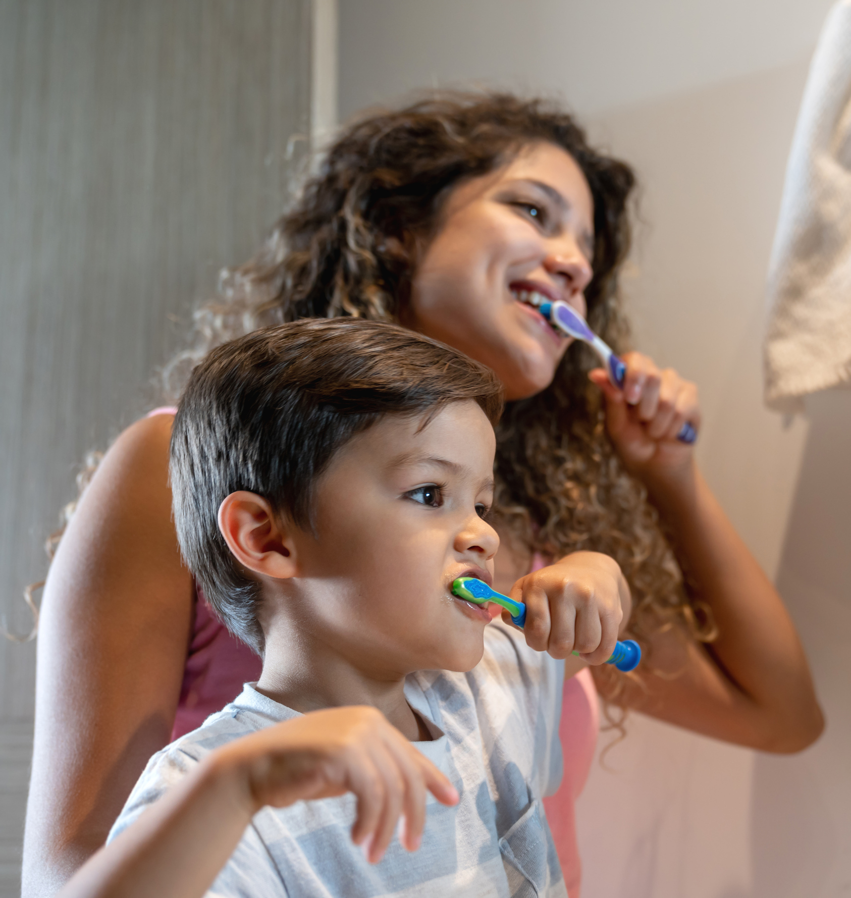 Mother and son at home brushing their teeth