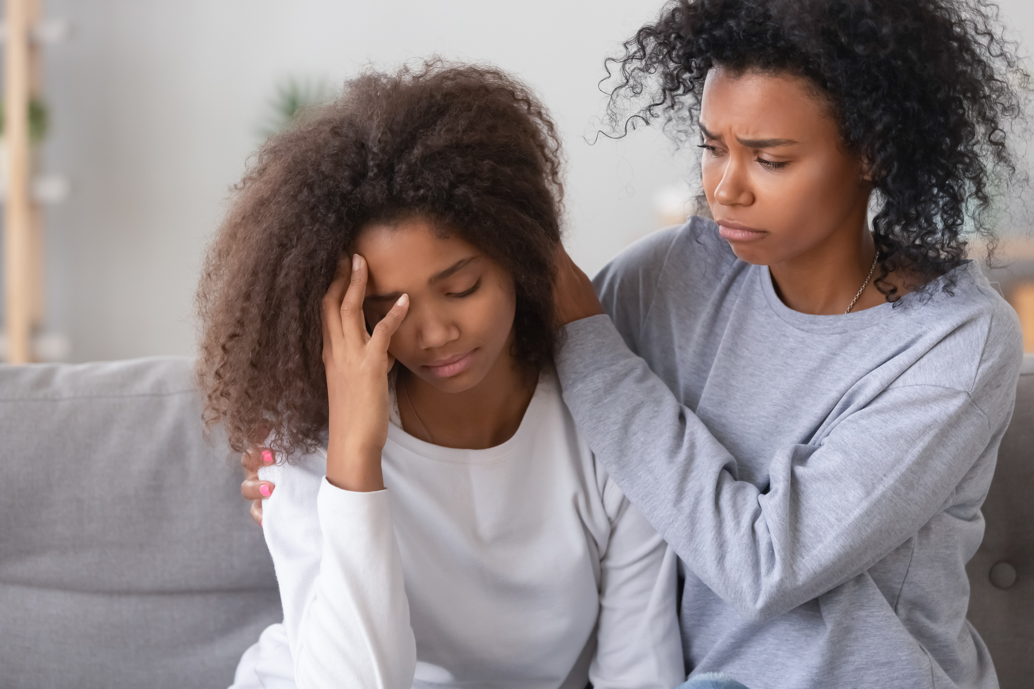 African young mother calming frustrated unhappy daughter