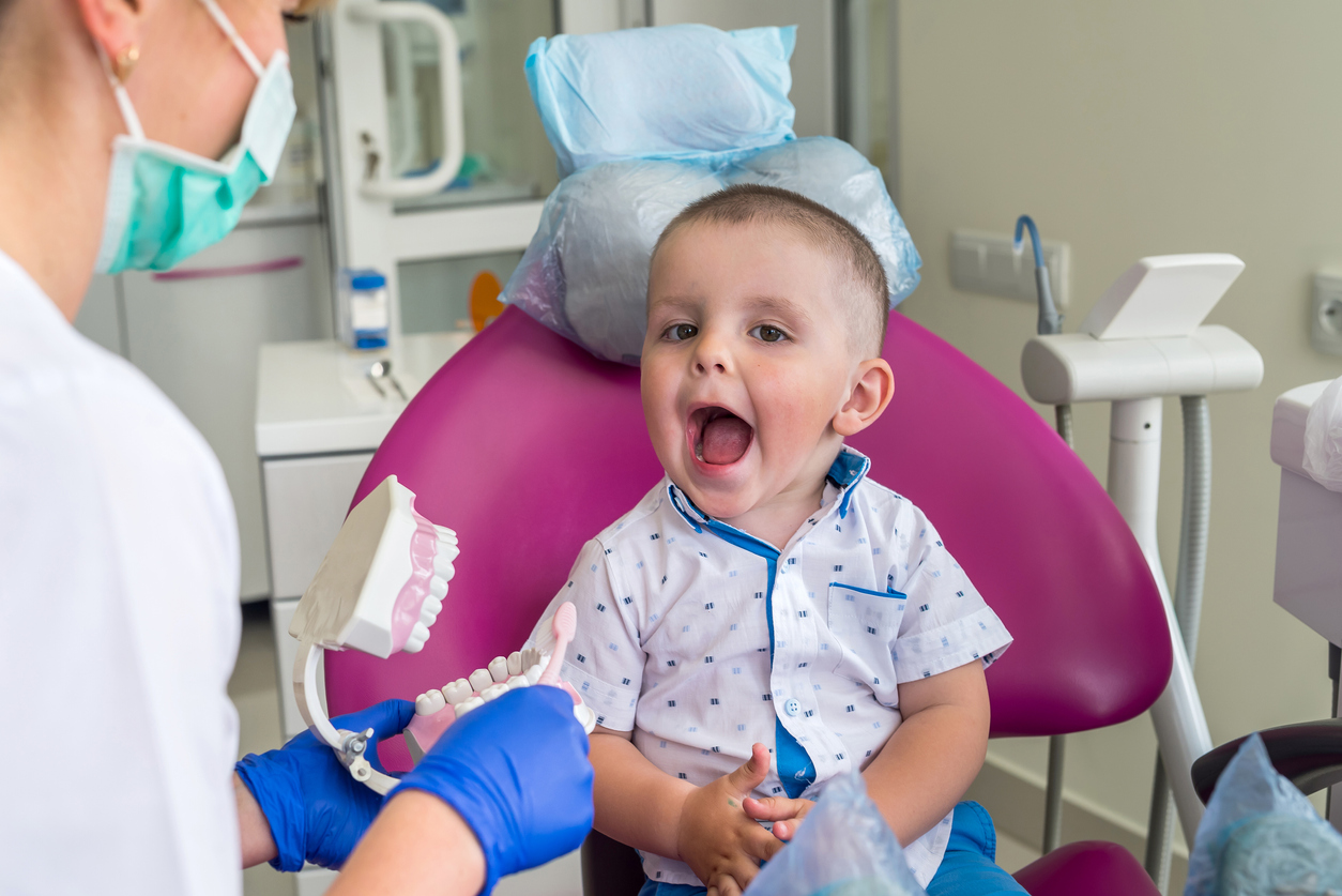 Little boy showing his teeth to a doctor