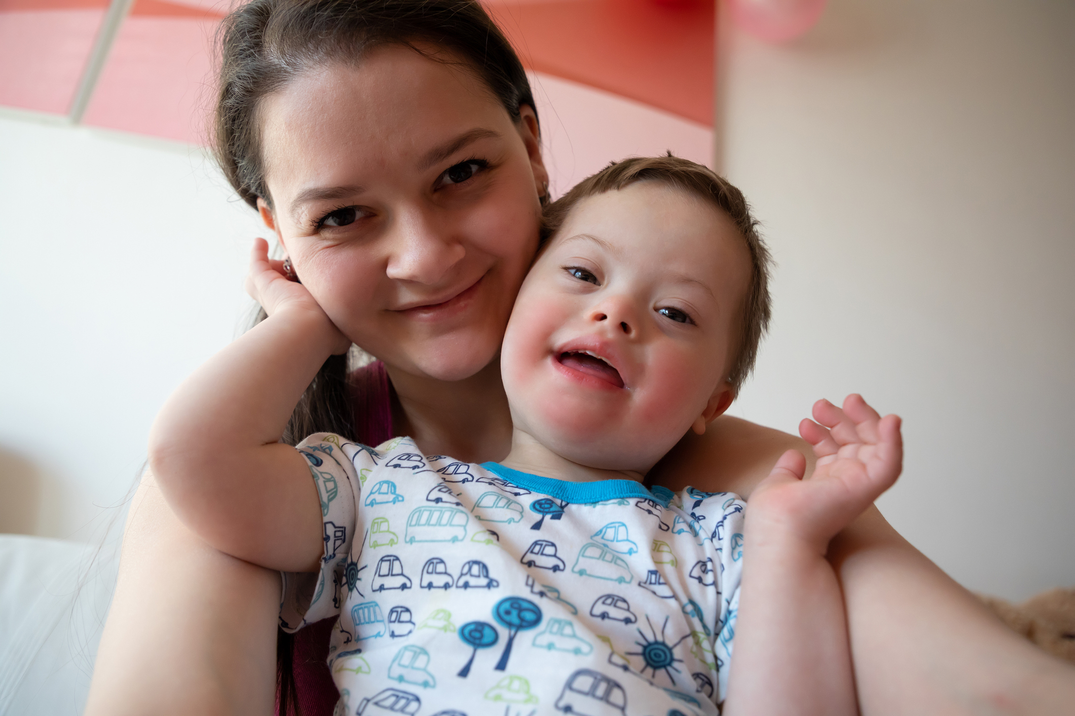 Selfie of cute small boy with Down syndrome with his mother