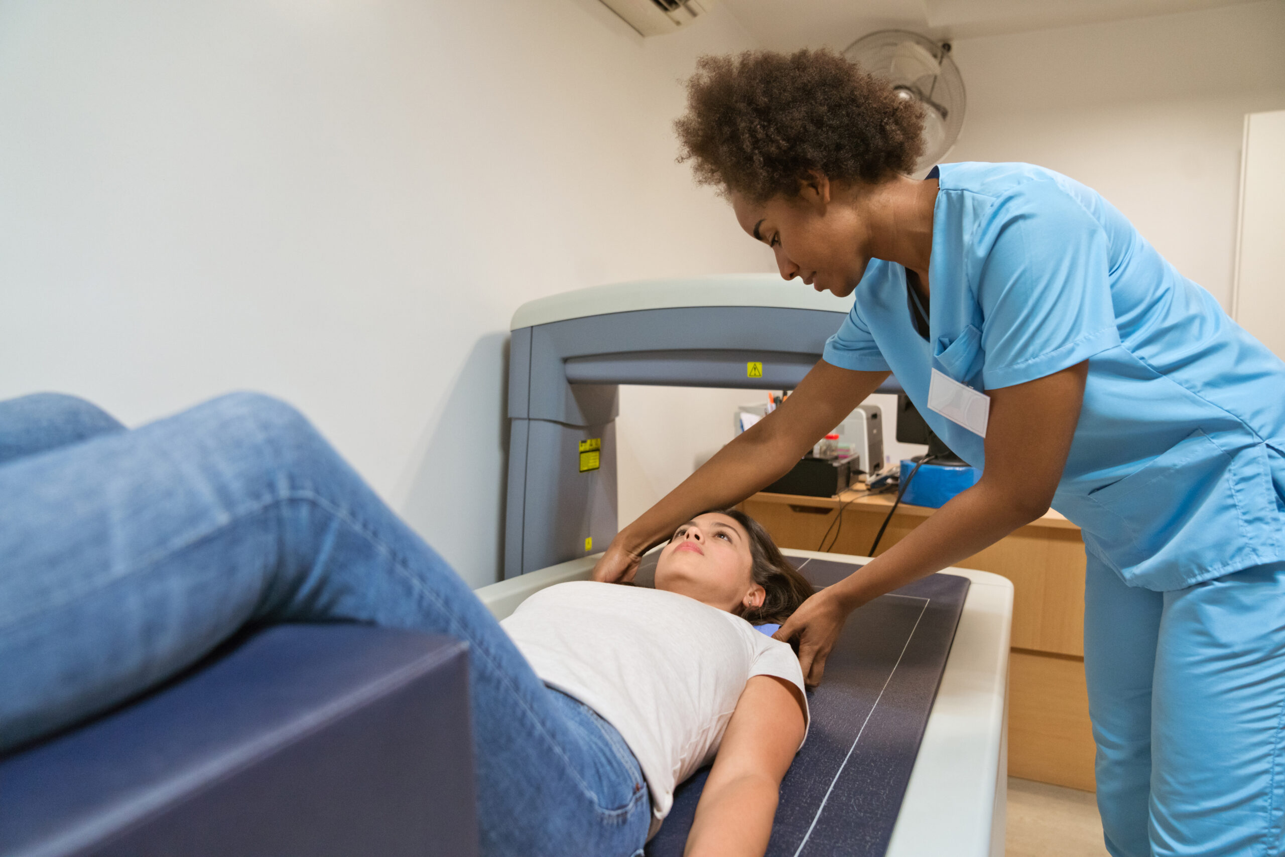 Female nurse preparing woman for bone density scan