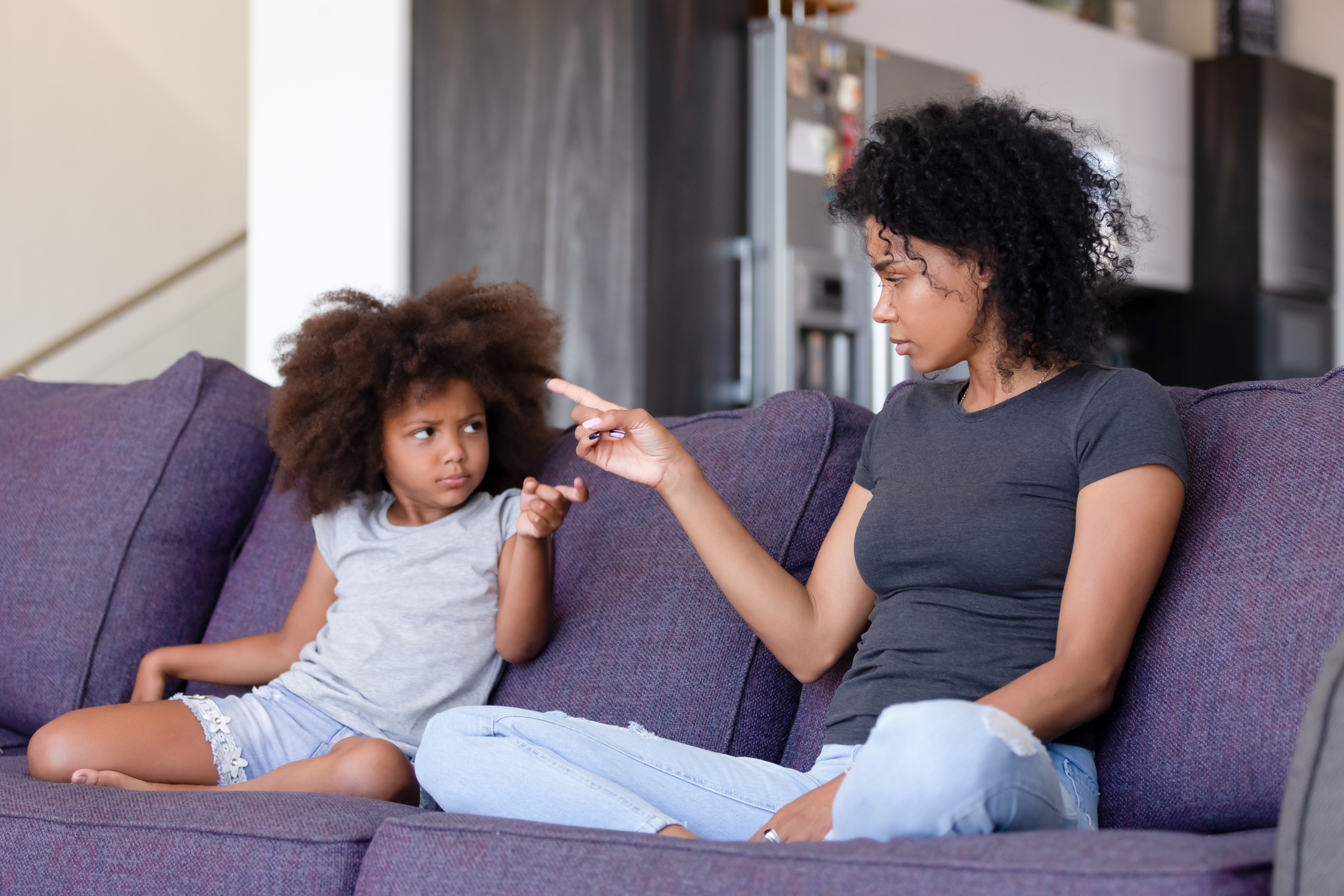 Upset African American mother and daughter quarreling at home