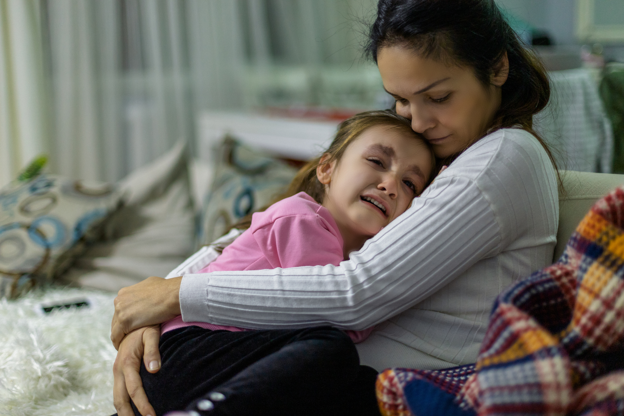 Crying girl and comforting mother