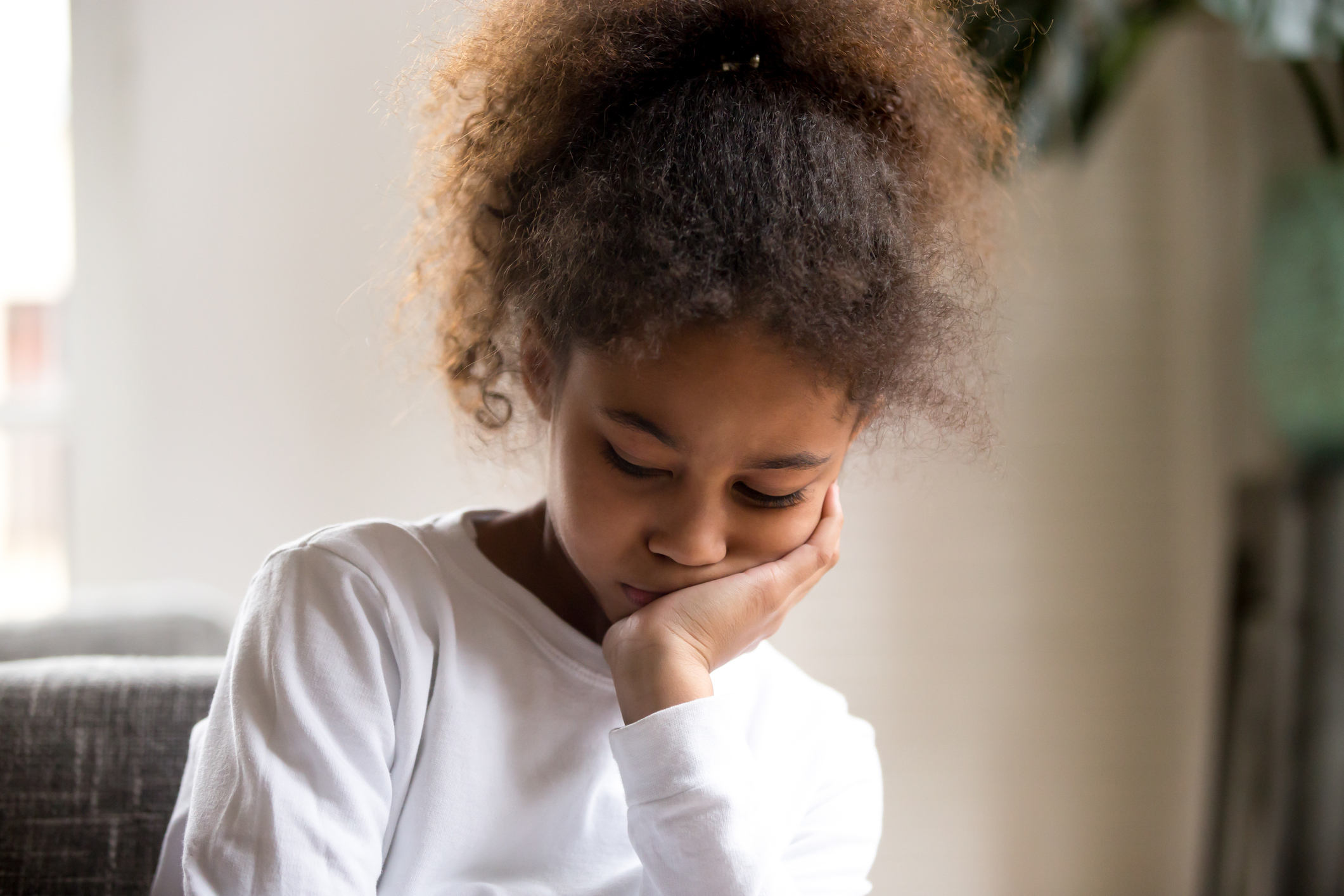 Upset African American girl feel down sitting alone