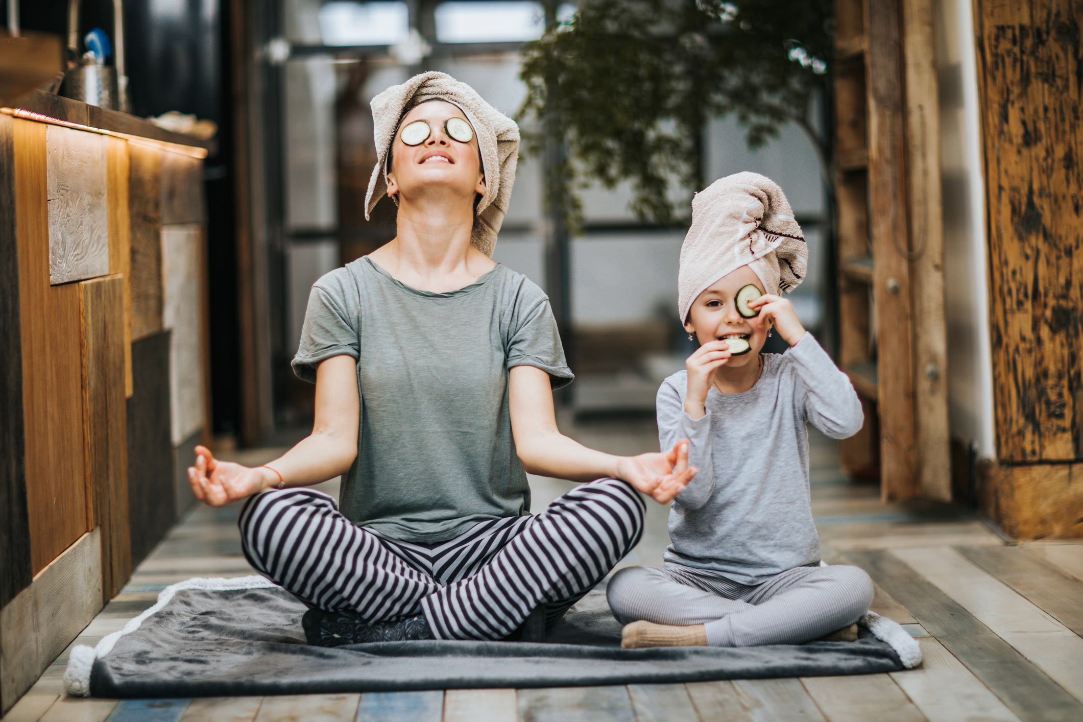 Relaxed mother and daughter exercising Yoga in the morning at home.