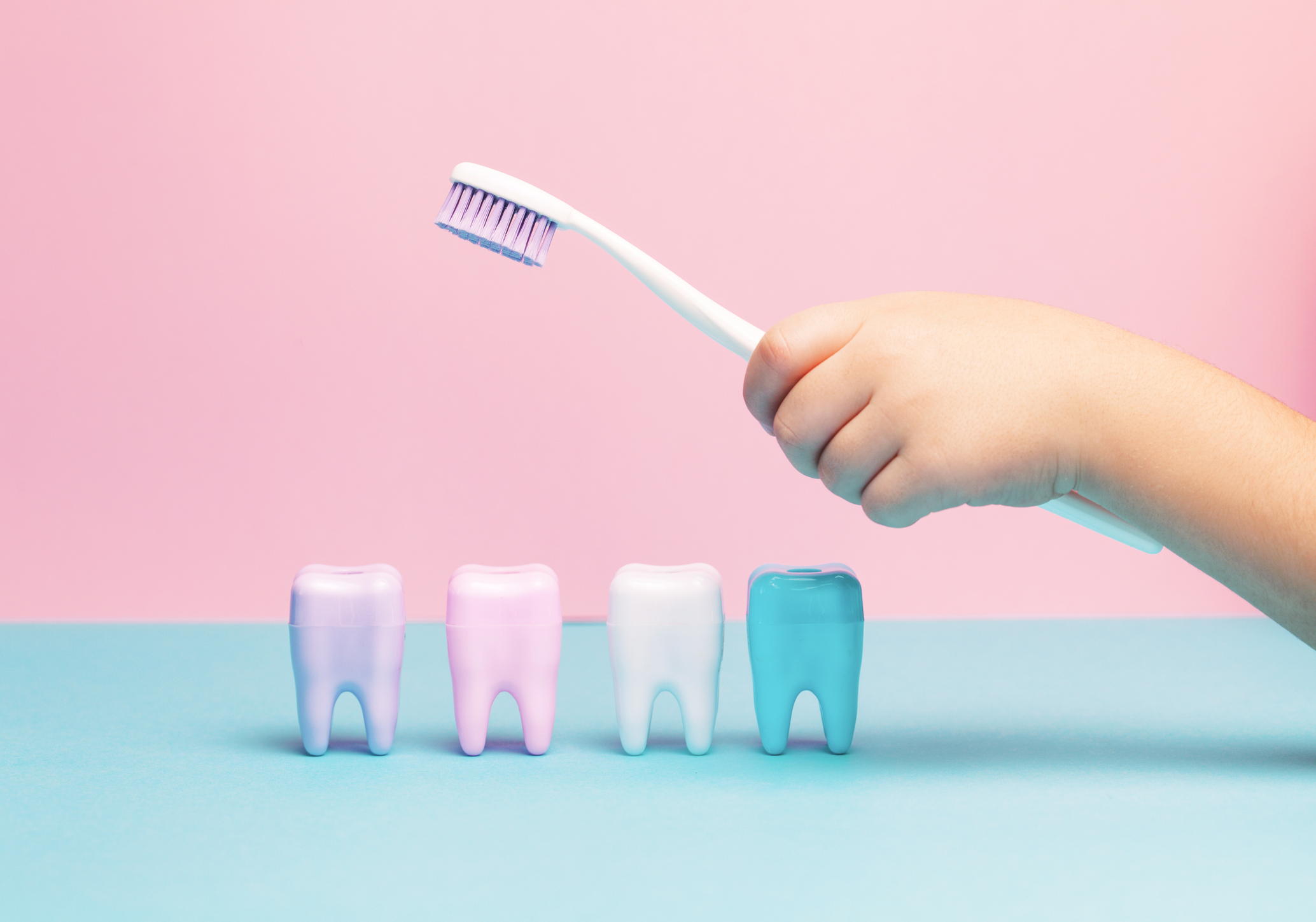 Child's hands holding big tooth and toothbrush