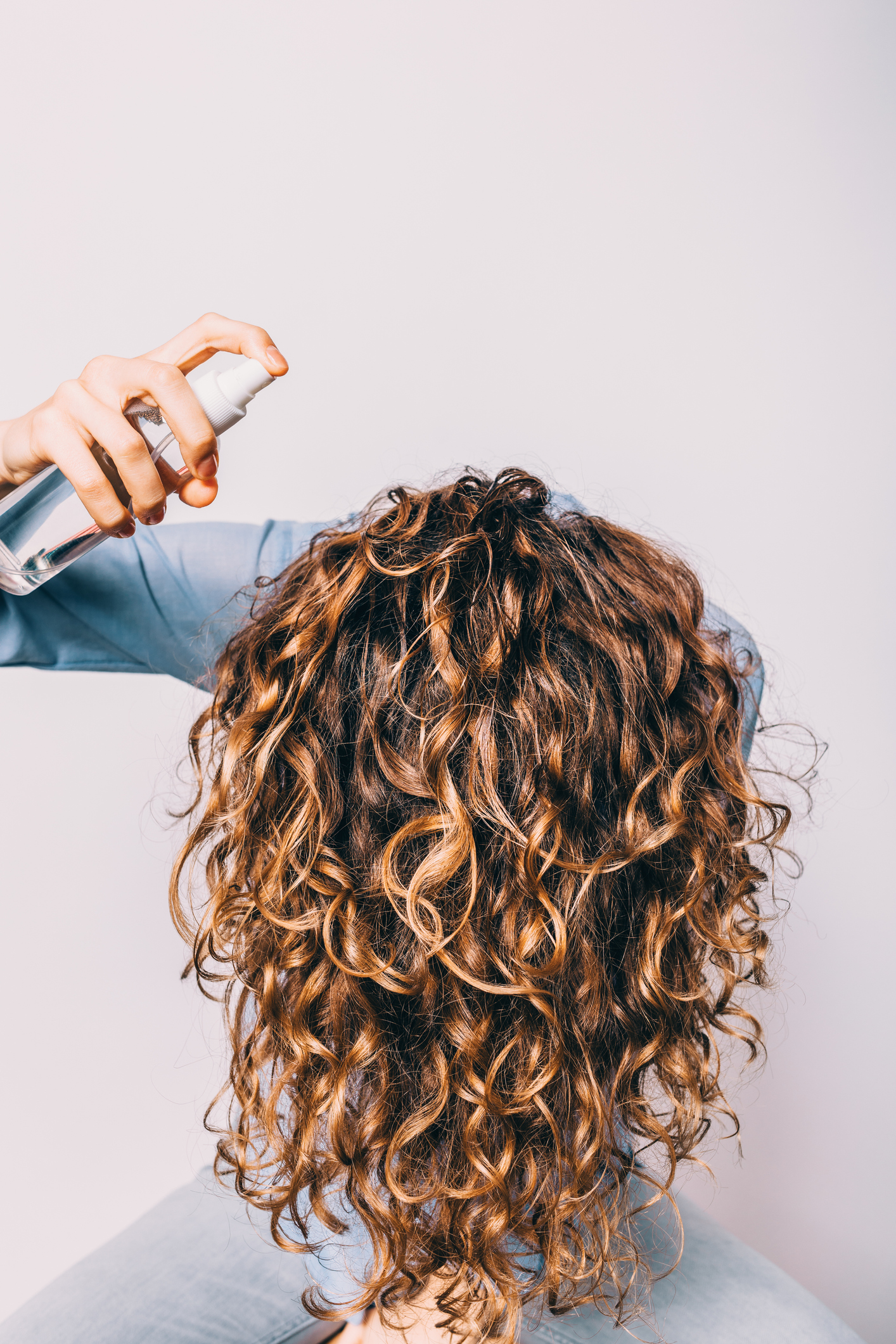 Head of young woman with long curly hair