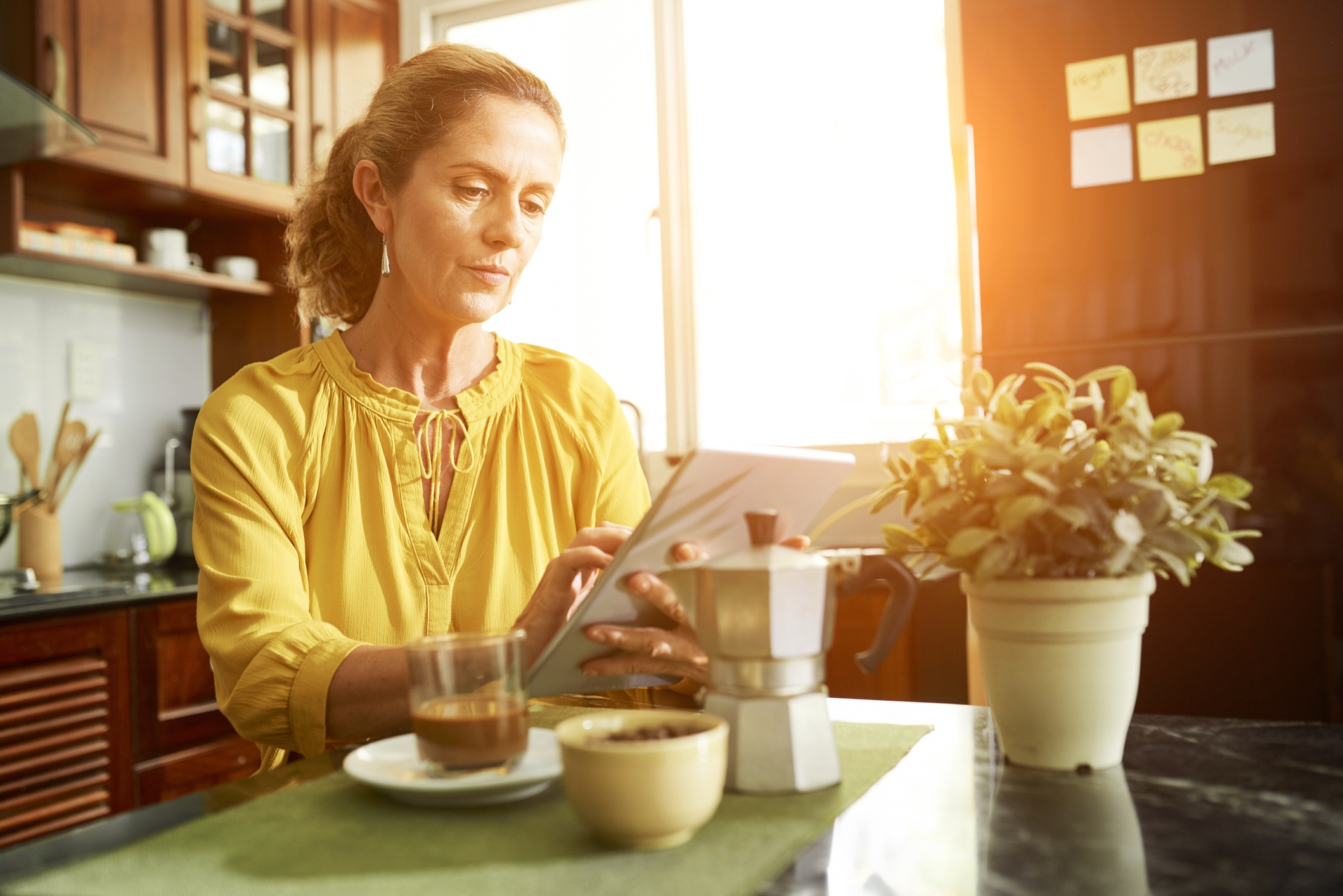 Woman working on tablet computer in kitchen