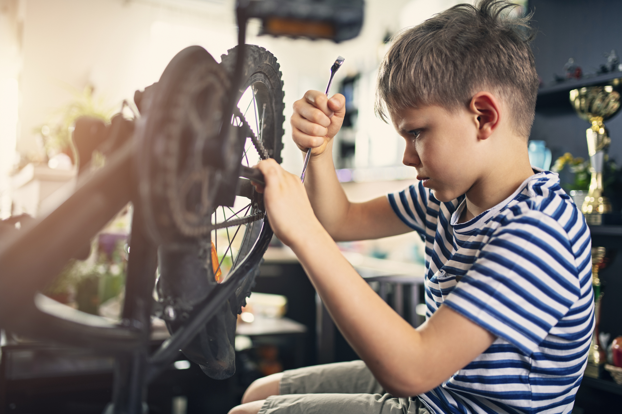 Little boy repairing a bicycle at home