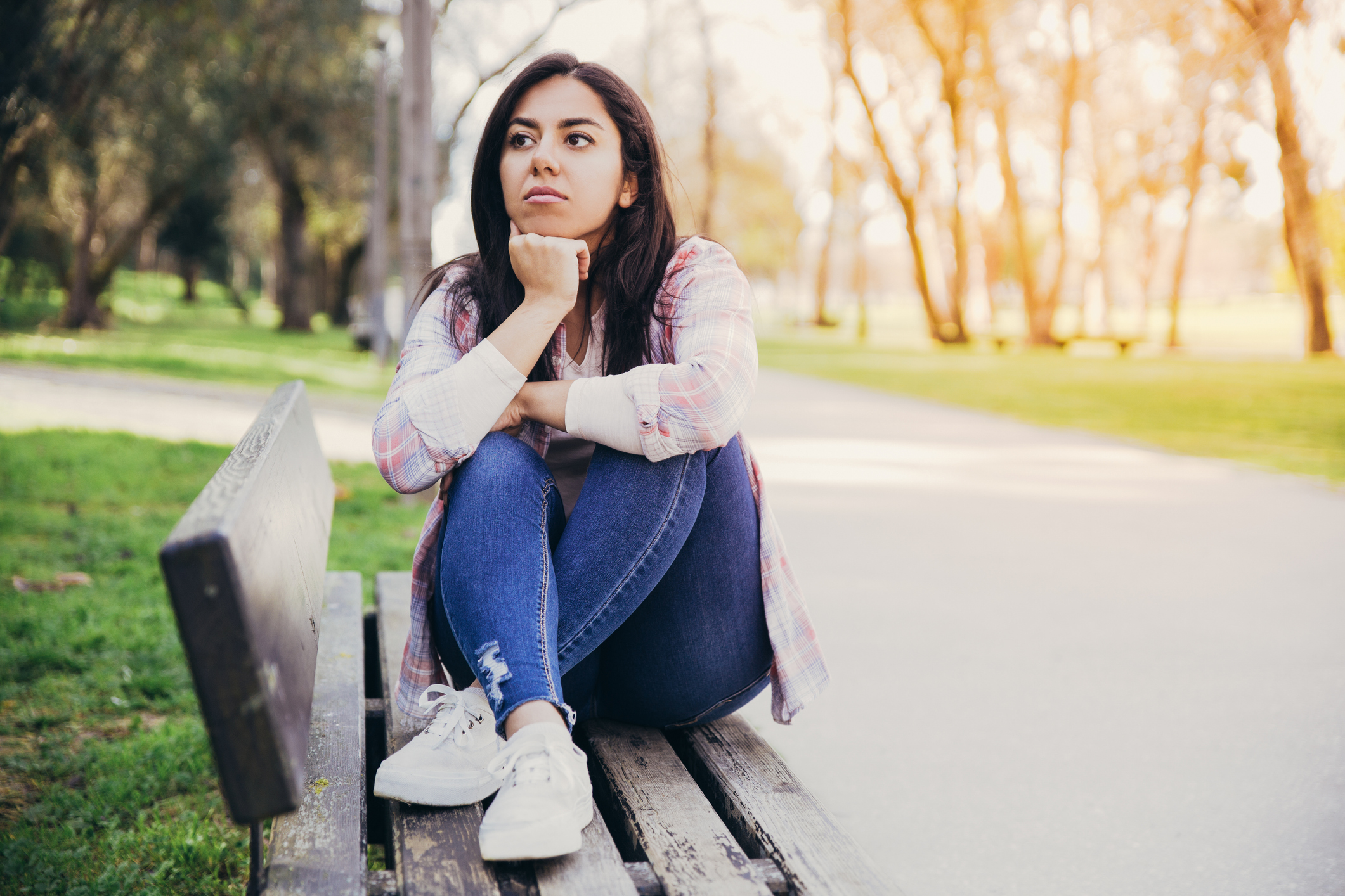 Serious attractive girl thinking about plans in park