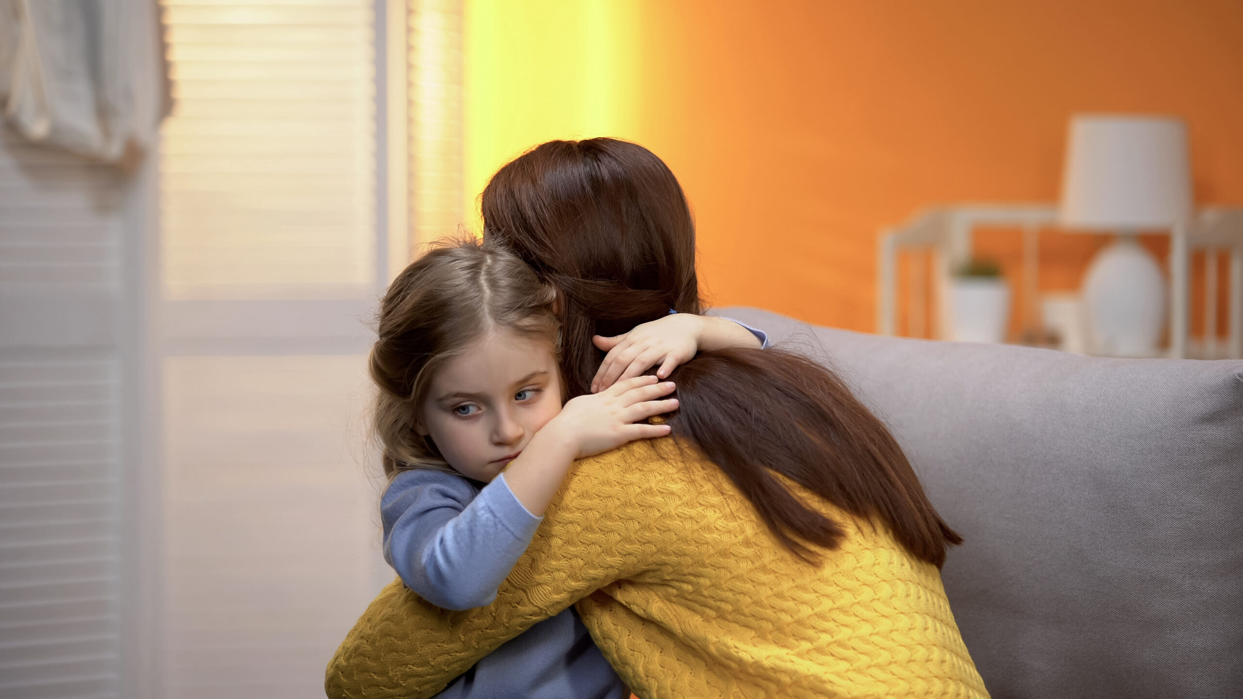 Little shy adopted girl hugging young female, beginning of new life in family