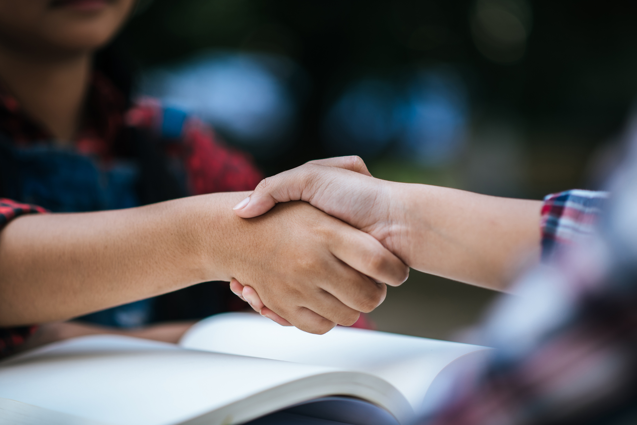 girls college student shake hand her friend at college park