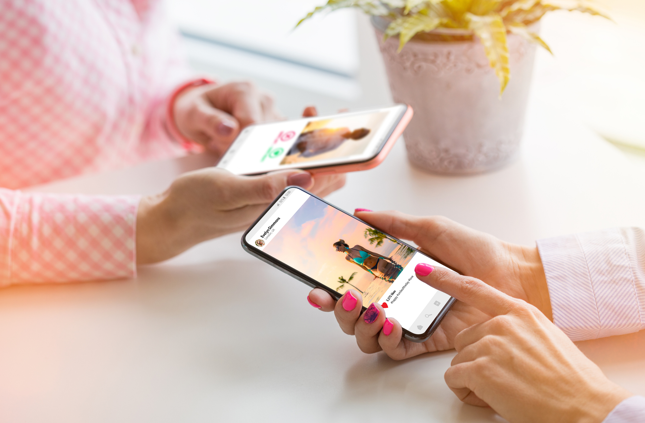 Two women using their mobile phones together