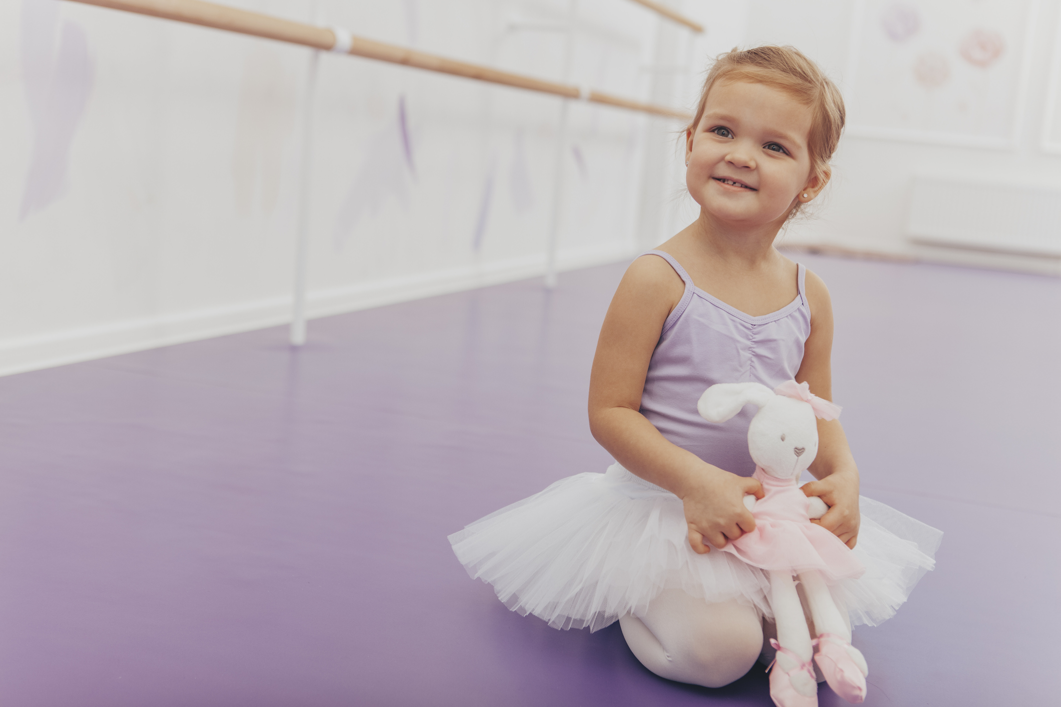 Cute little girl exercising at ballet school