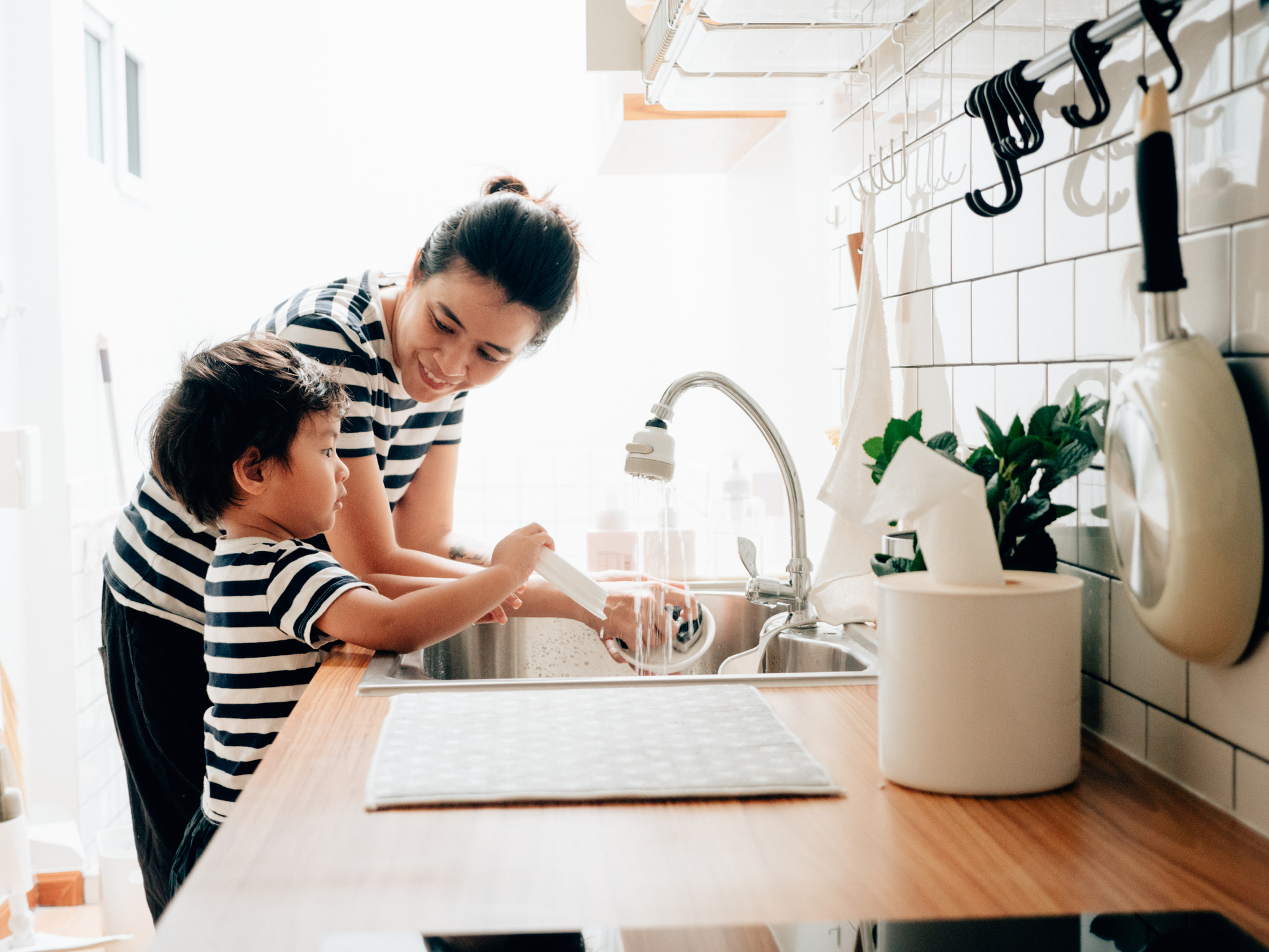 Little Baby Boy Wiping Clean Dishes with His Mother.