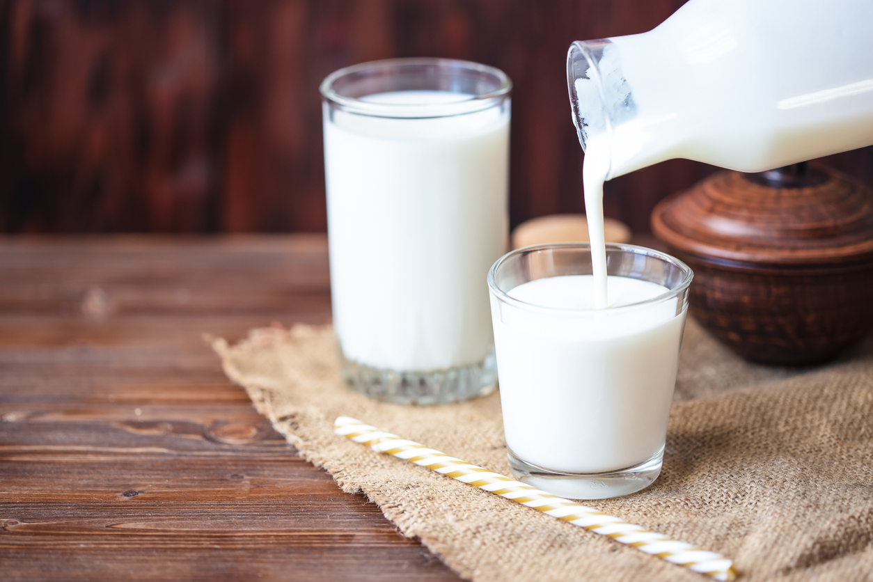 Pouring homemade kefir, yogurt with probiotics Probiotic cold fermented dairy drink Trendy food and drink Copy space Rustic style