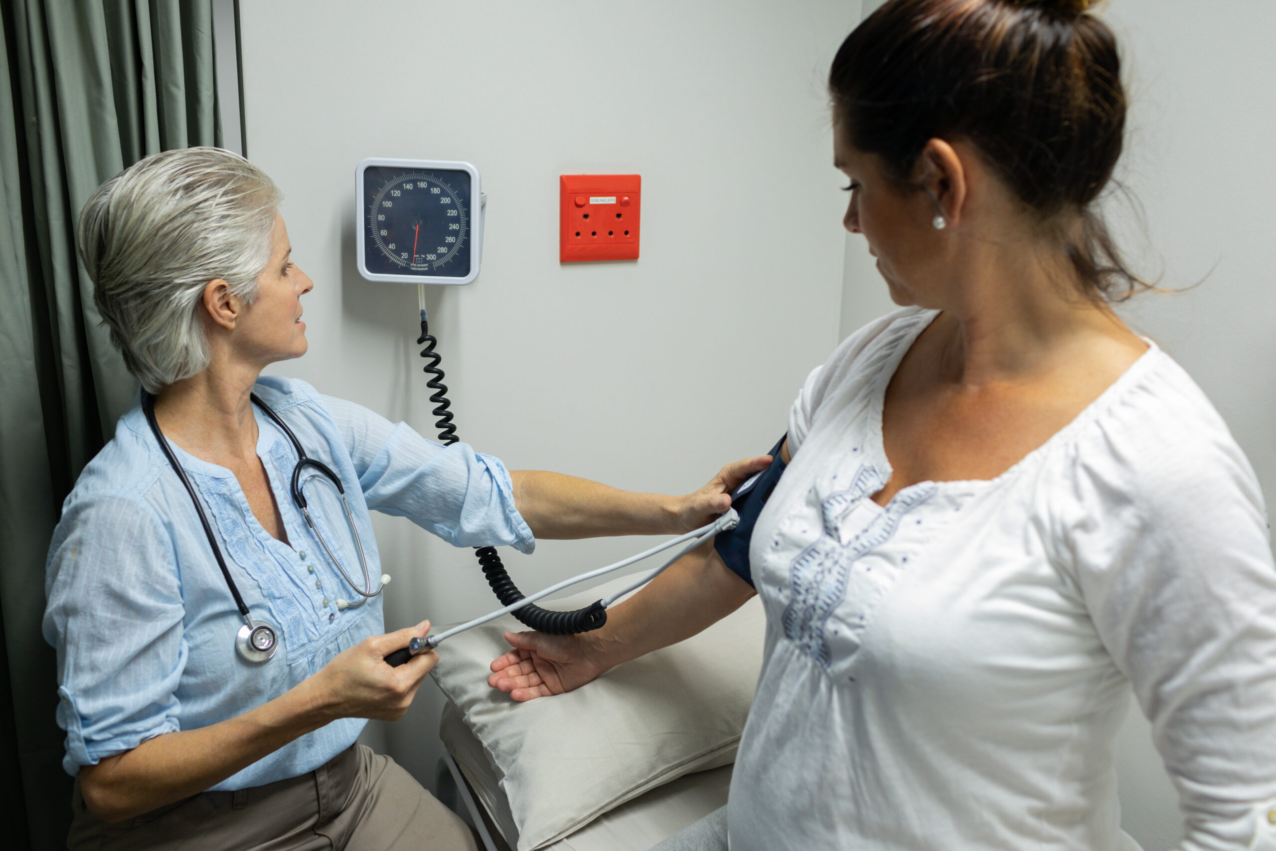 Female doctor checking blood pressure of a pregnant woman