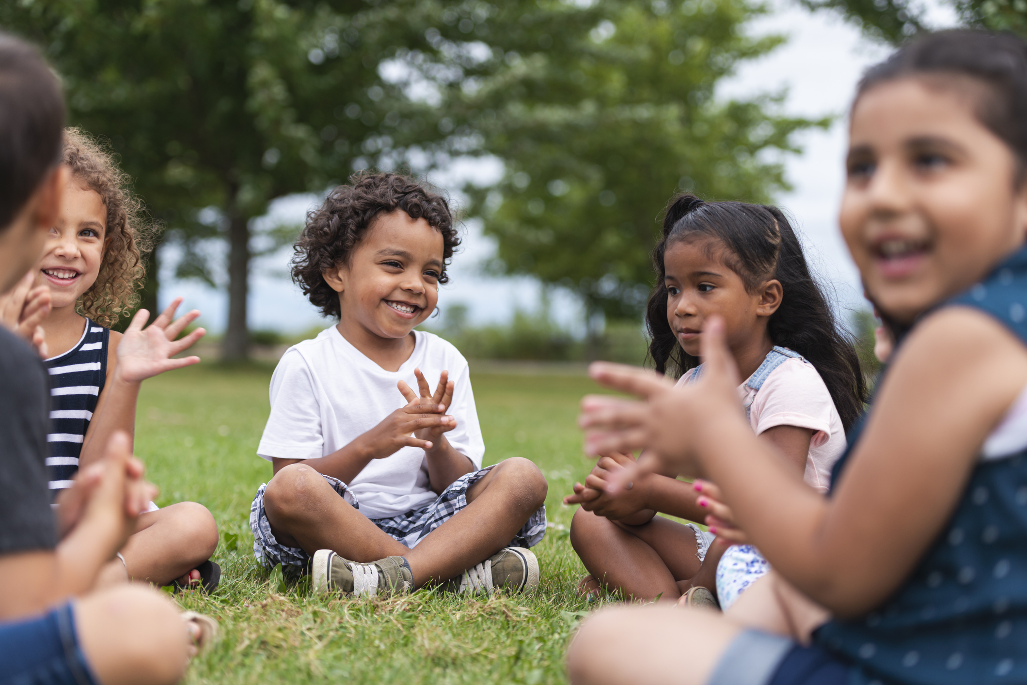 A Multi-Ethnic Group of Young Children are Clapping Outside