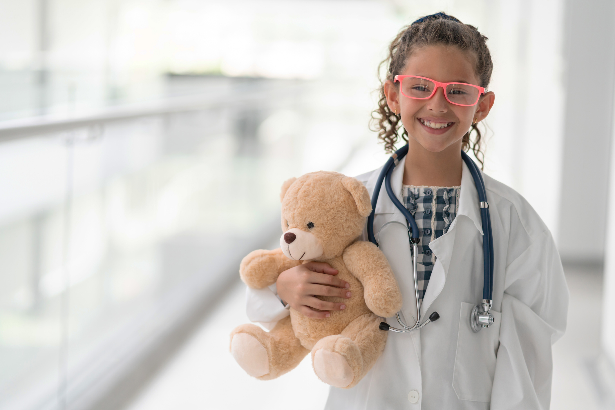 Happy girl playing to be a doctor at a hospital