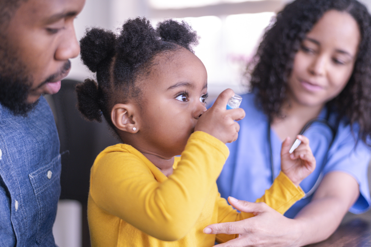 Girl at doctor's appointment using an asthma inhaler