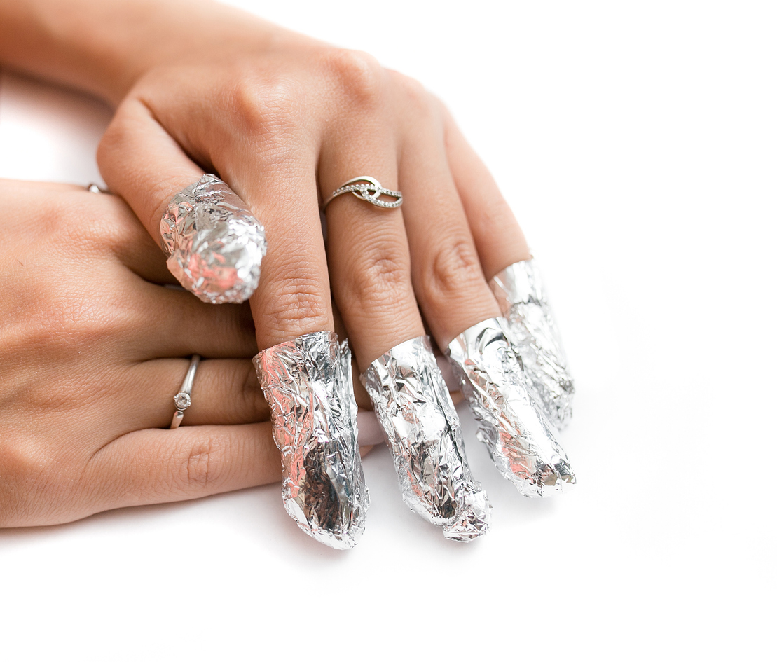 Removal of gel nail polish using a foil. Isolated on white.