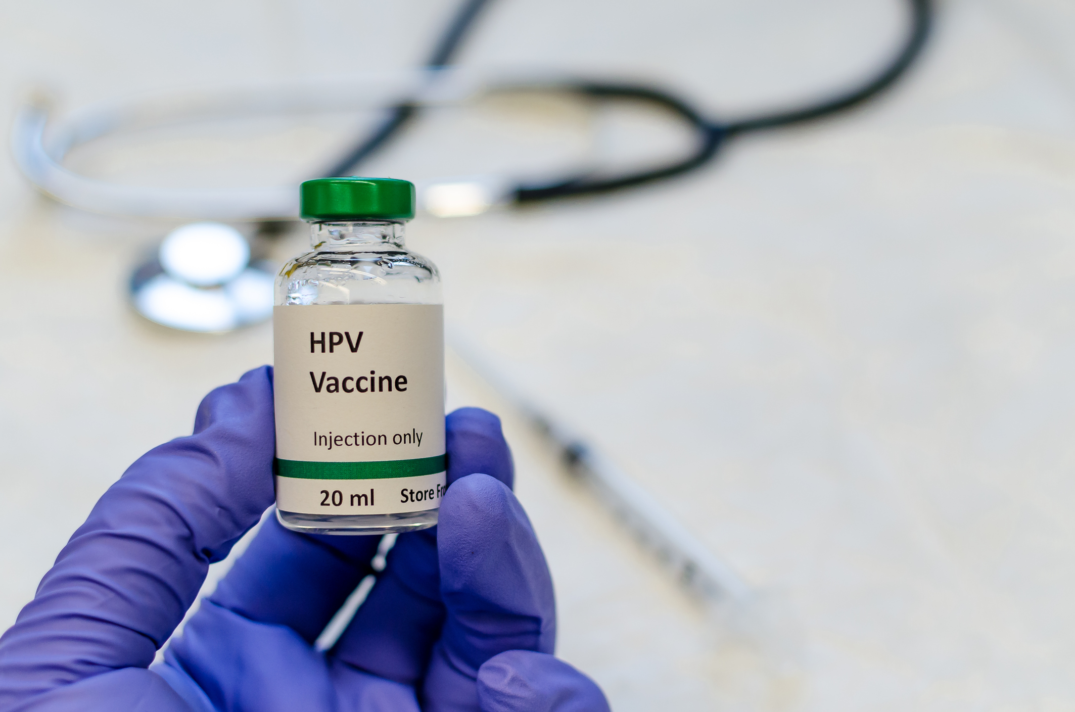 HPV vaccine vial with syringe and stethoscope at the background