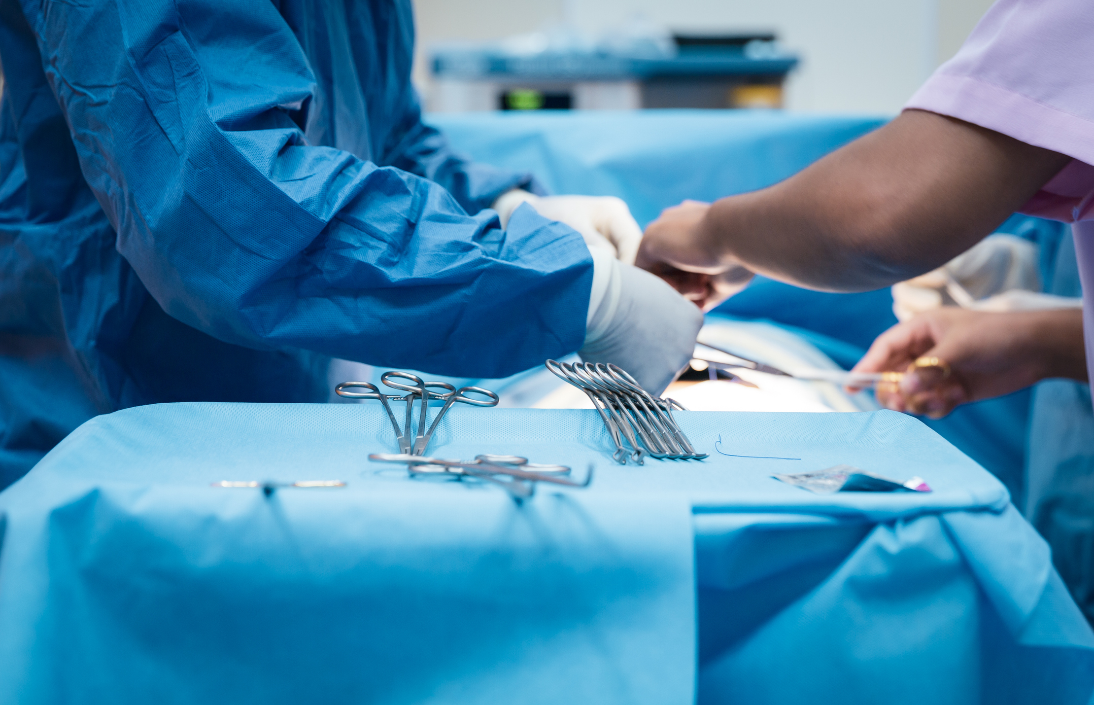 Doctor and nurse in the operating room with patient on the operating table in hospital