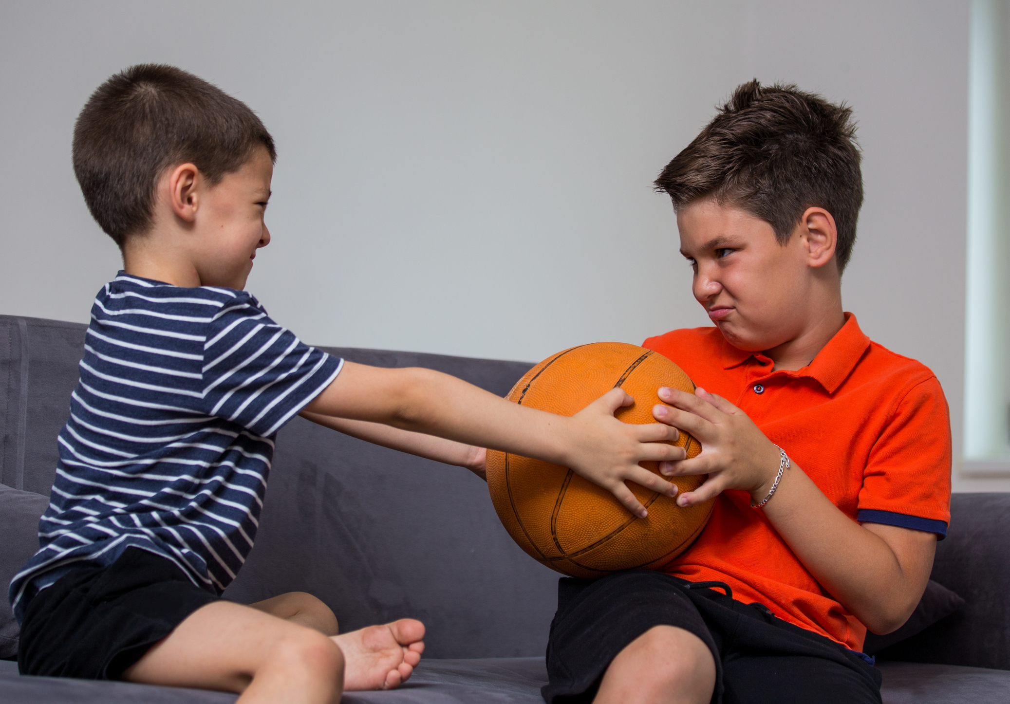 Two little kids, brothers fighting over a toy. the conflict between children over a ball