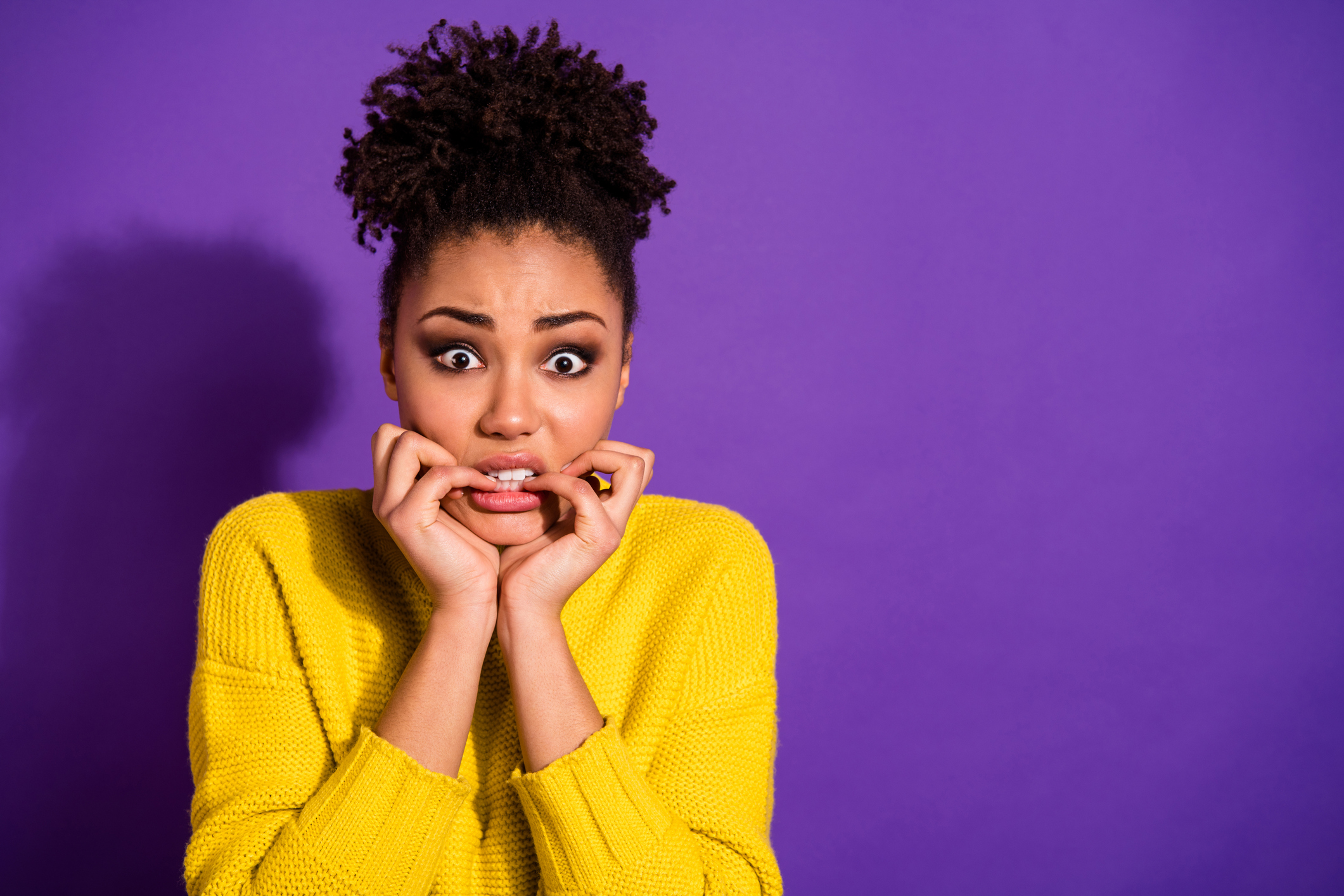 Portrait of terrified beautiful youth nails bite hear horrible news wear stylish trendy pullover jumper isolated over purple violet background