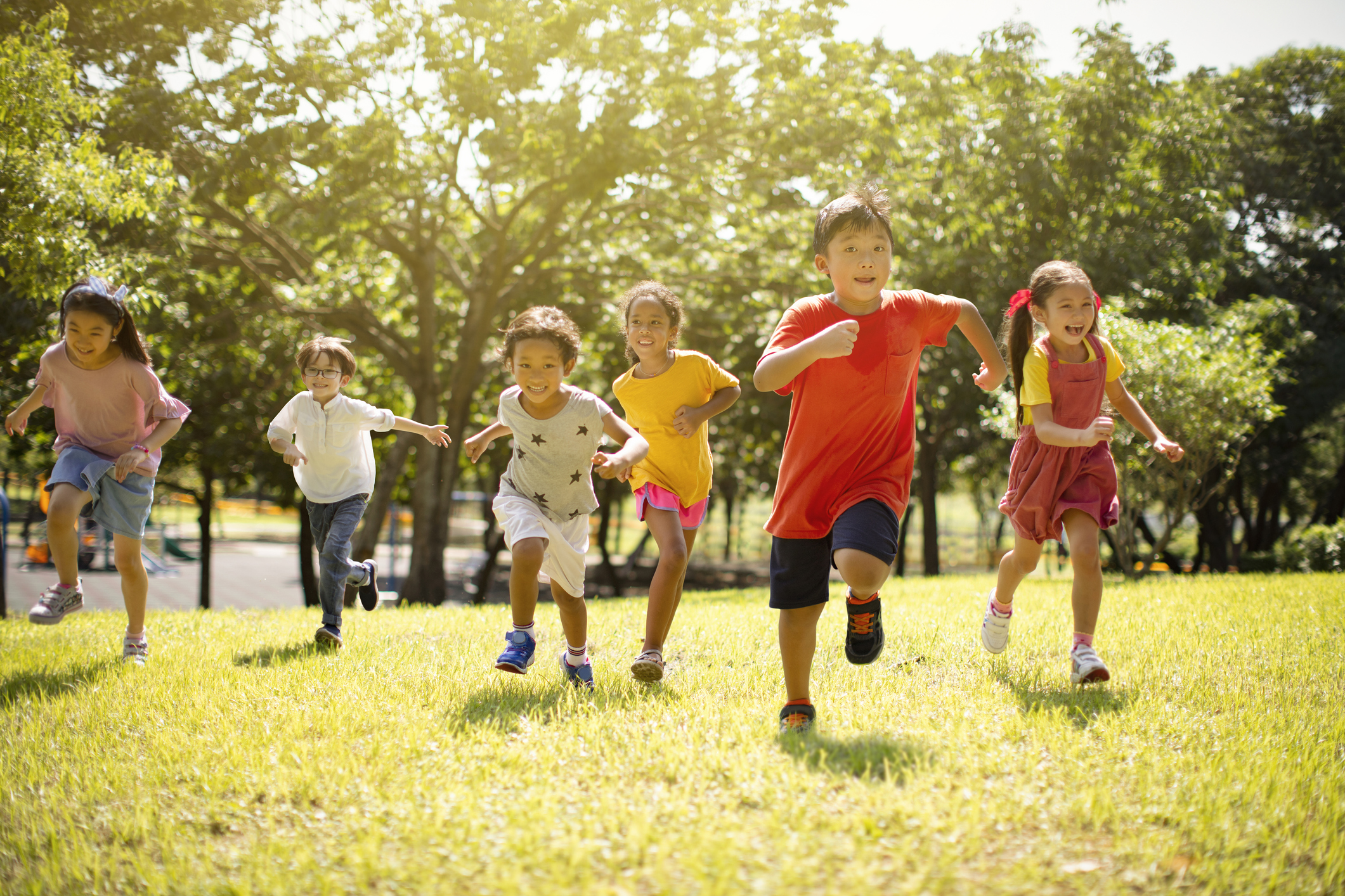 Multi-ethnic group of school children laughing and running