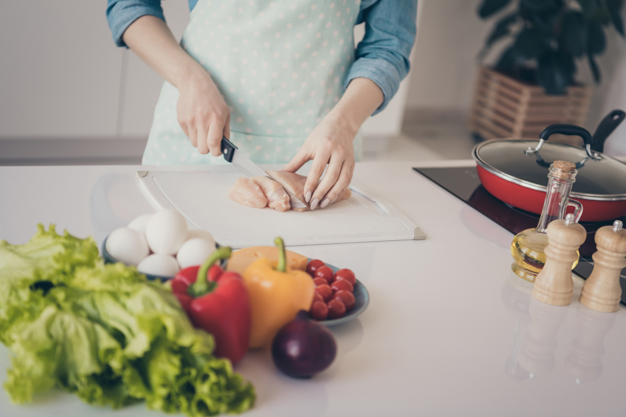 Cropped photo of house wife making perfect dish for family cut hen meat ready clean vegetables on table