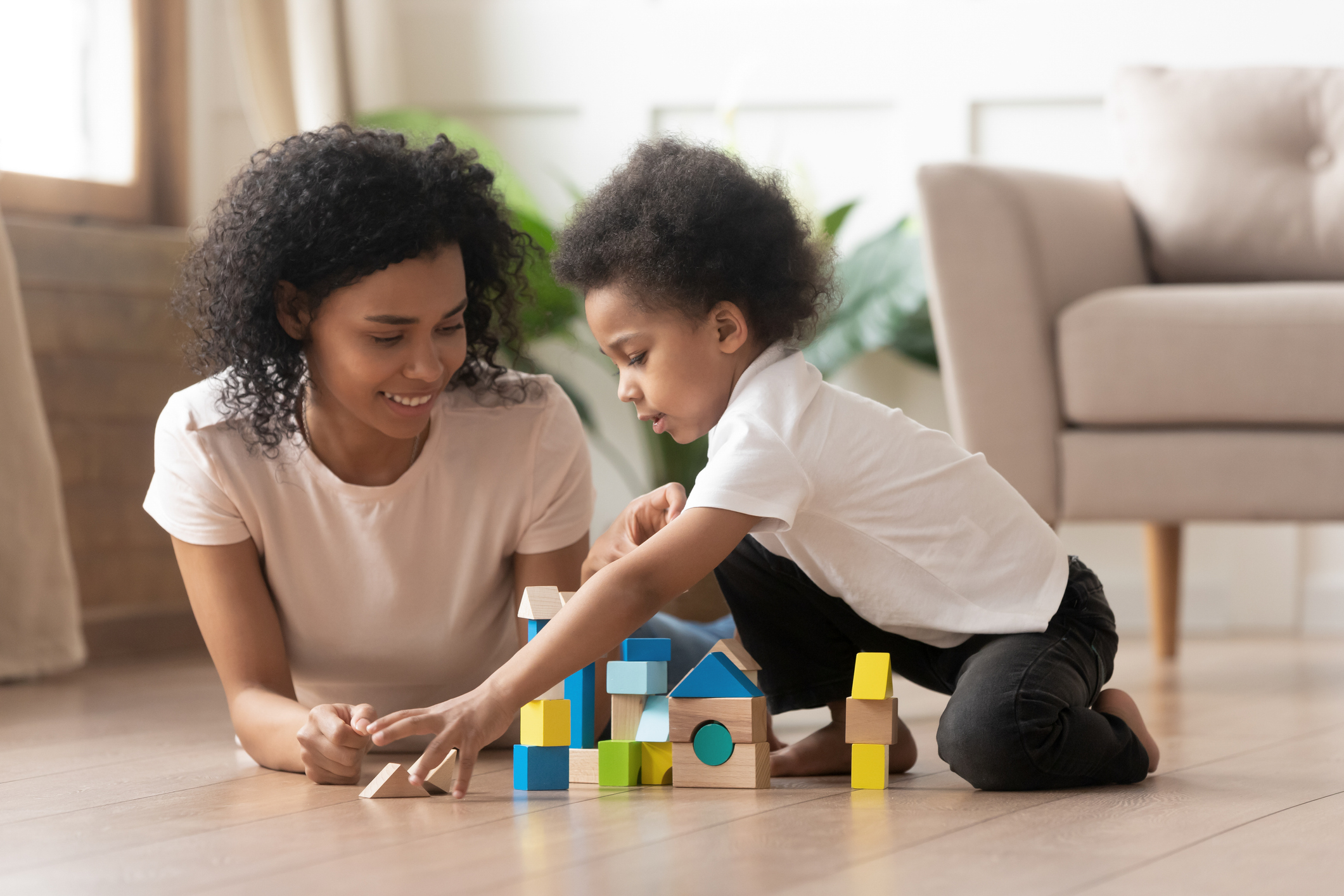 Smiling black mom have fun playing with little son