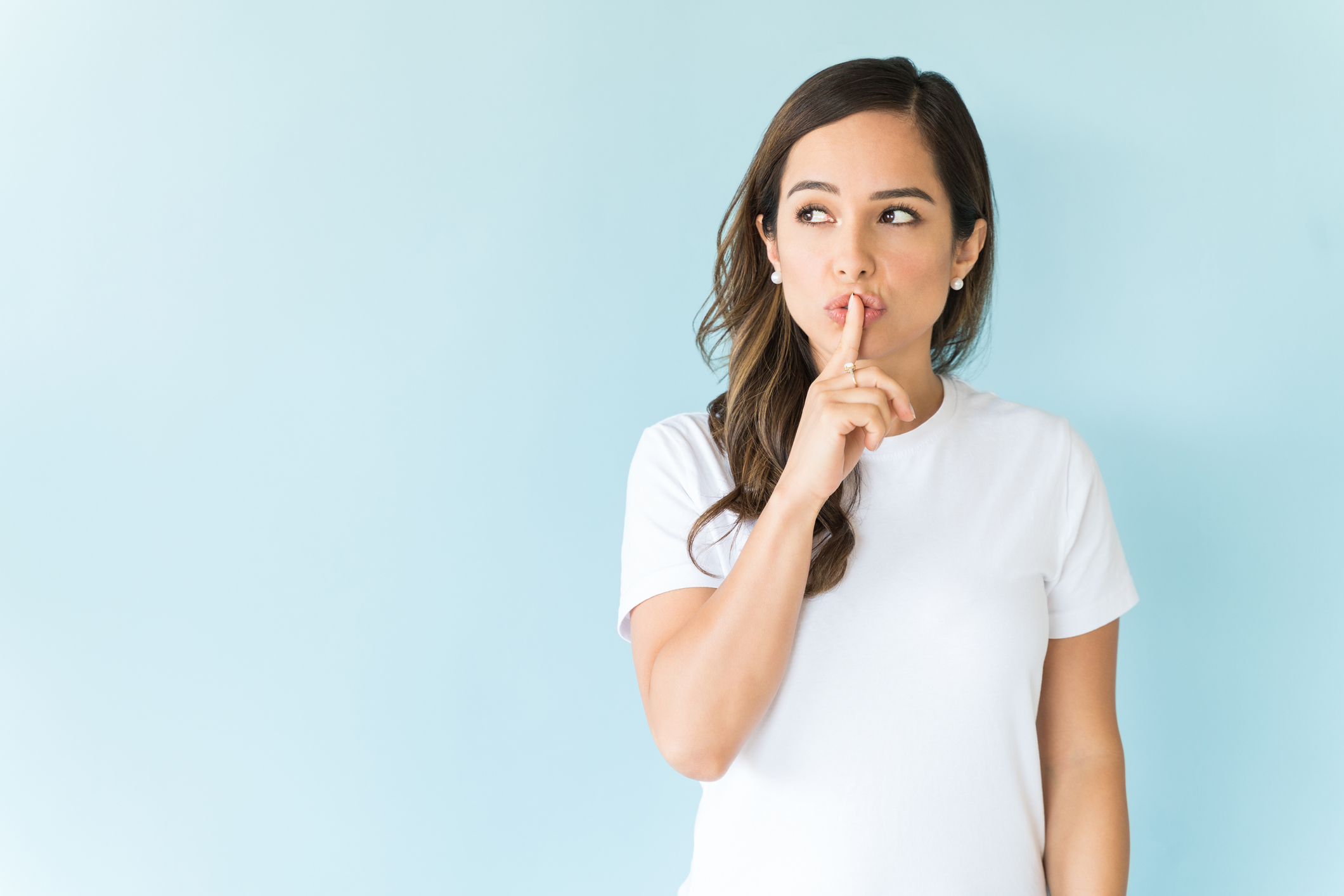 Female Model Is Standing With Finger On Lips In Studio