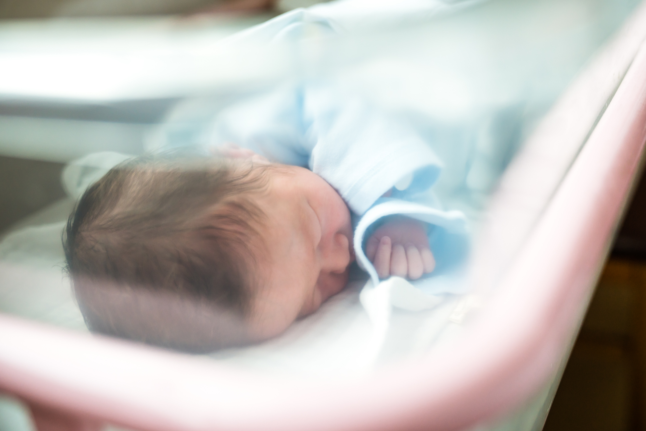 Newborn Baby Sleeping In Hospital Bassinet