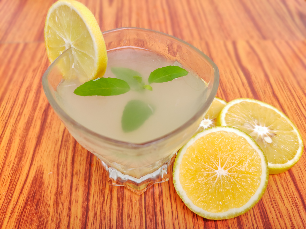 Lemon juice with green leaf in a glass with lemon slices